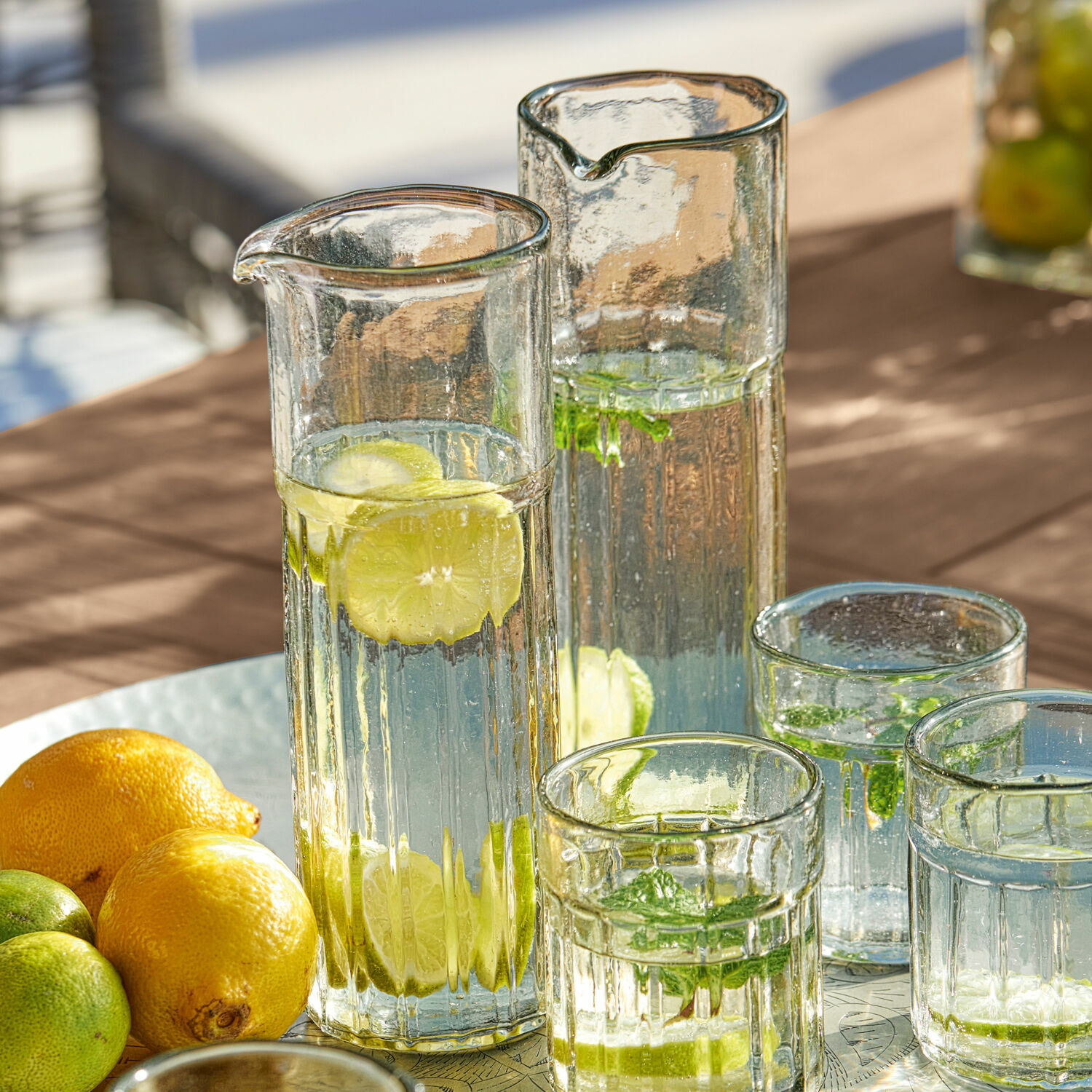Karaffe 2er Set Roseville Gläserne Karaffen und Gläser mit Wasser, Zitrone und Minze auf Tisch, erfrischendes Sommergetränk