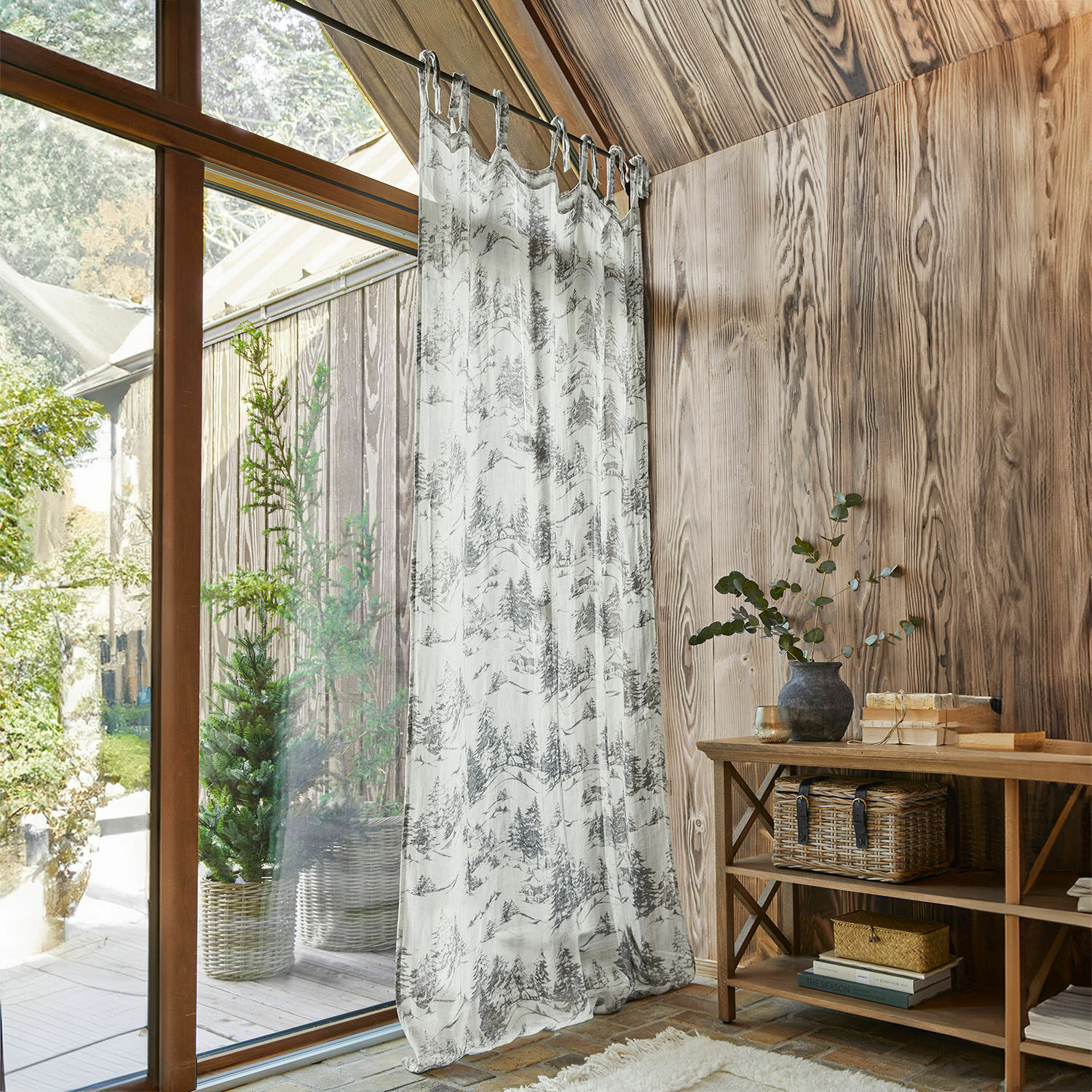 Gardine Héroux Transparenter Vorhang mit Baum-Motiv in Grau-Weiß in einem Holzraum mit natürlichem Licht