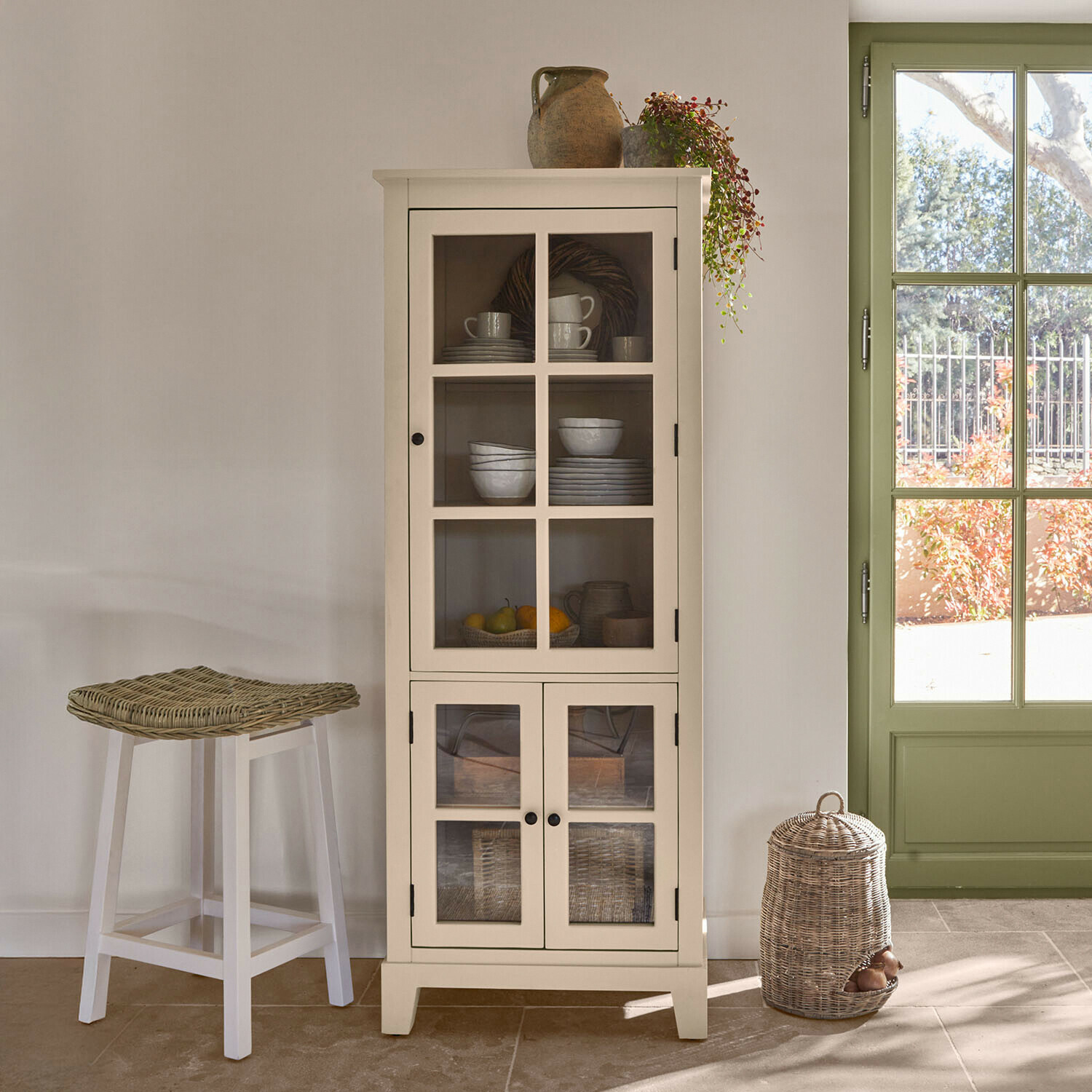 Schrank Domérise Weiße Holzvitrine mit Glastüren und Keramikdekorationen in hellem Raum