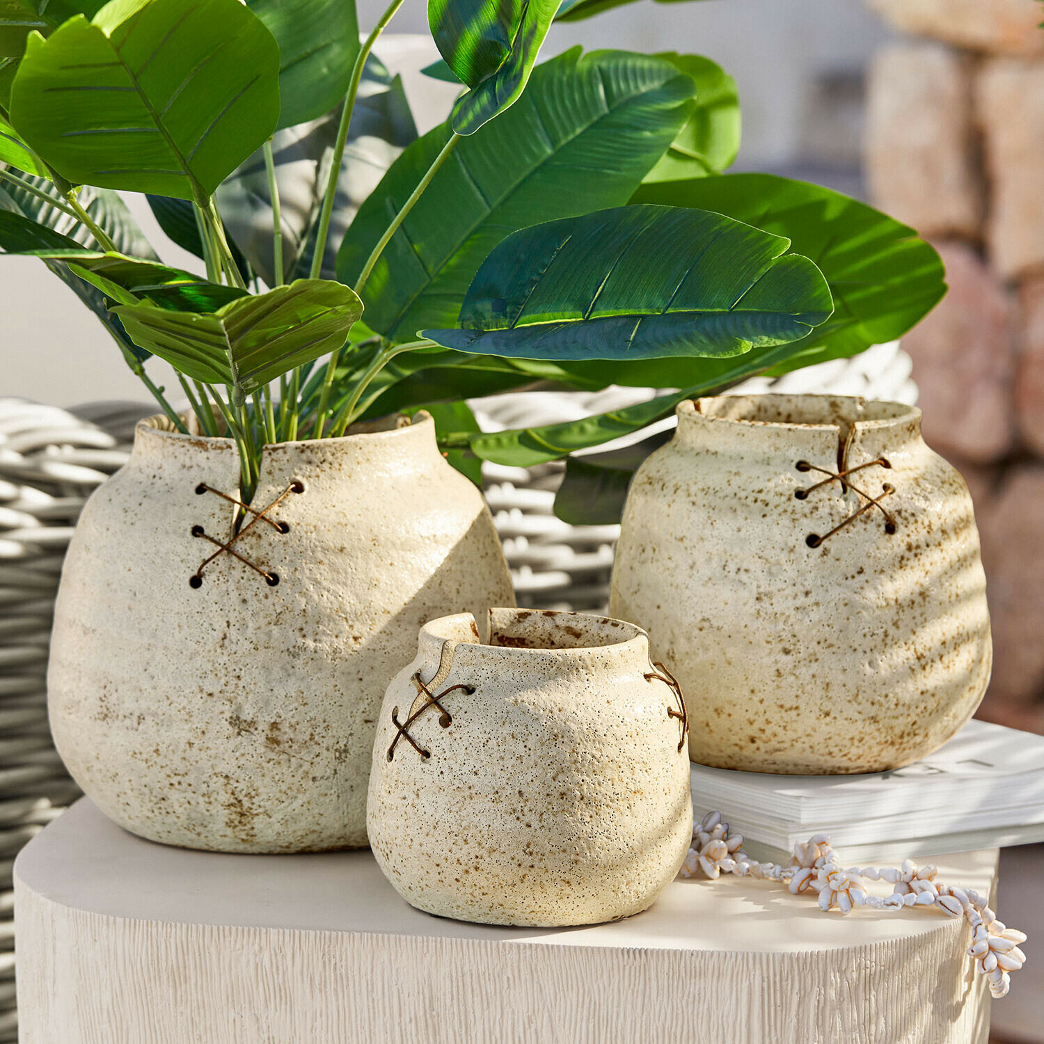Set aus drei cremefarbenen Keramikvasen mit dekorativer Schnürung, stilvolle Wohnaccessoires