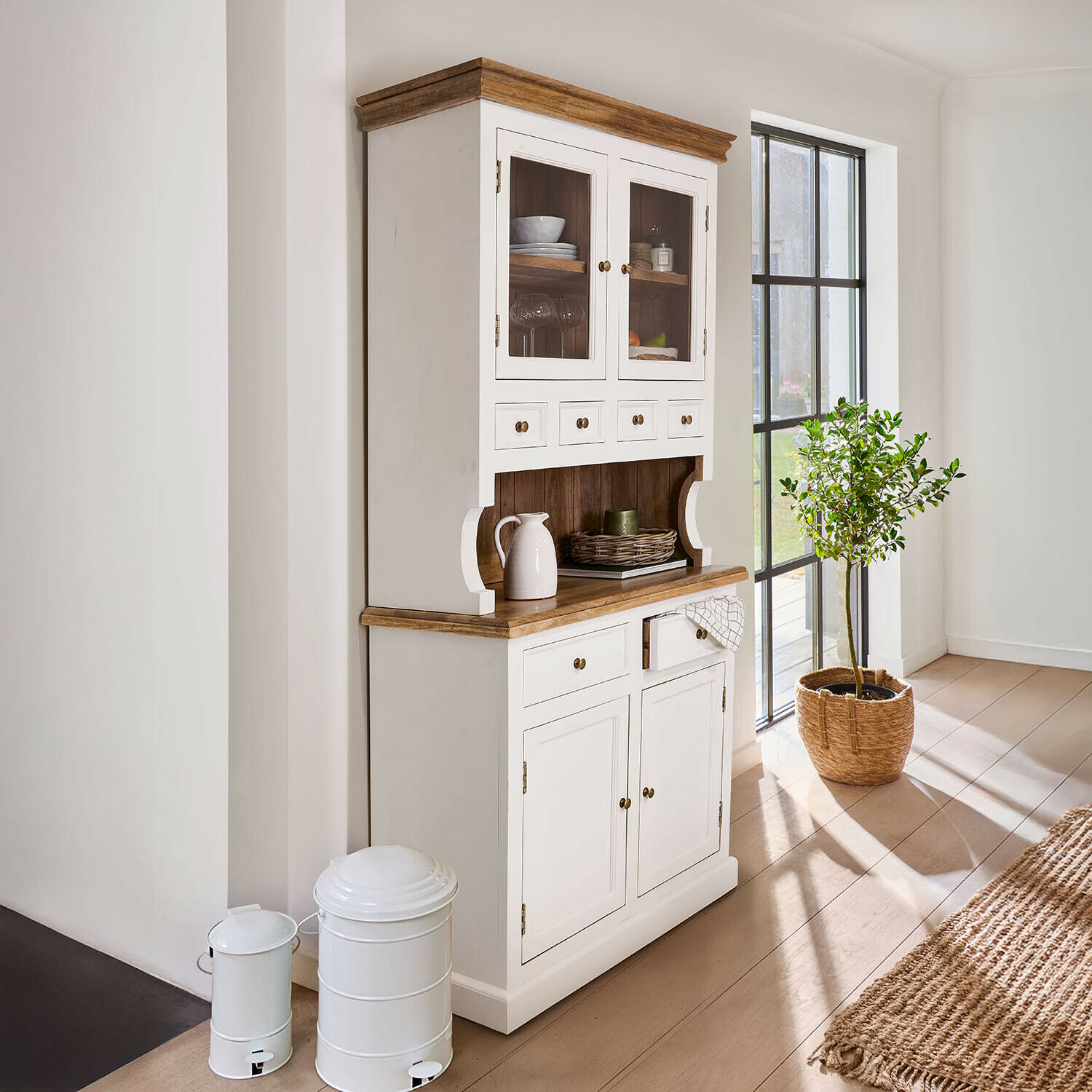 Weißer Holzbuffet mit natürlicher Arbeitsplatte und Glastüren in hellem, sonnigem Raum