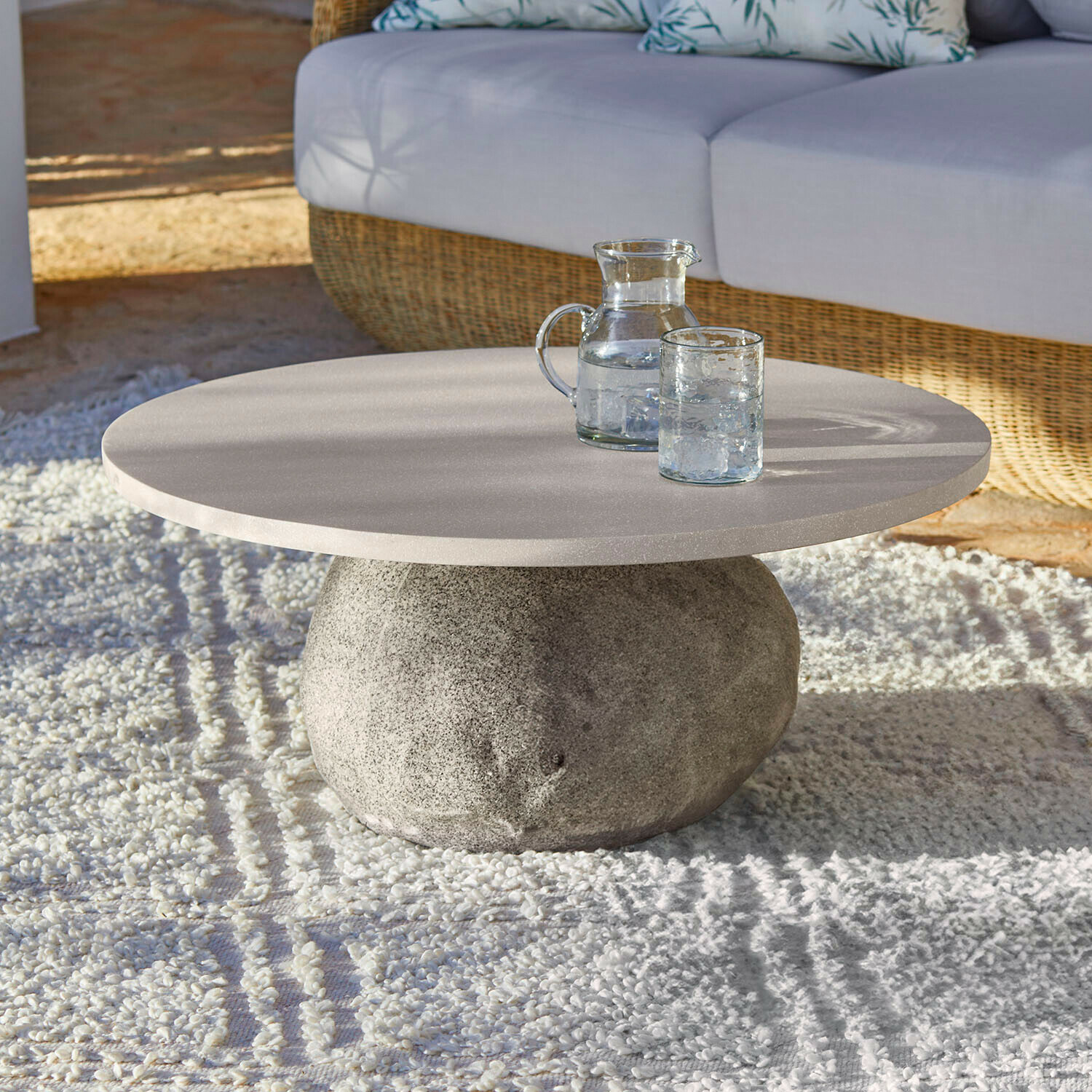 Couchtisch Orivana Runder Couchtisch mit steinerner Basis und hellem Tischplatte auf Teppich im Wohnzimmer