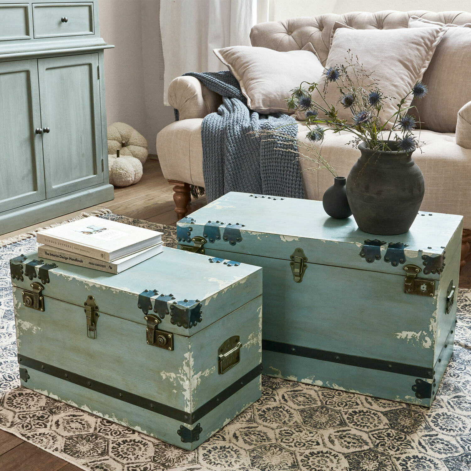 Truhe 2er Set Gorman Zwei blaue Holzkoffer mit Metallbeschlägen auf Teppich im Wohnzimmer mit beigem Sofa