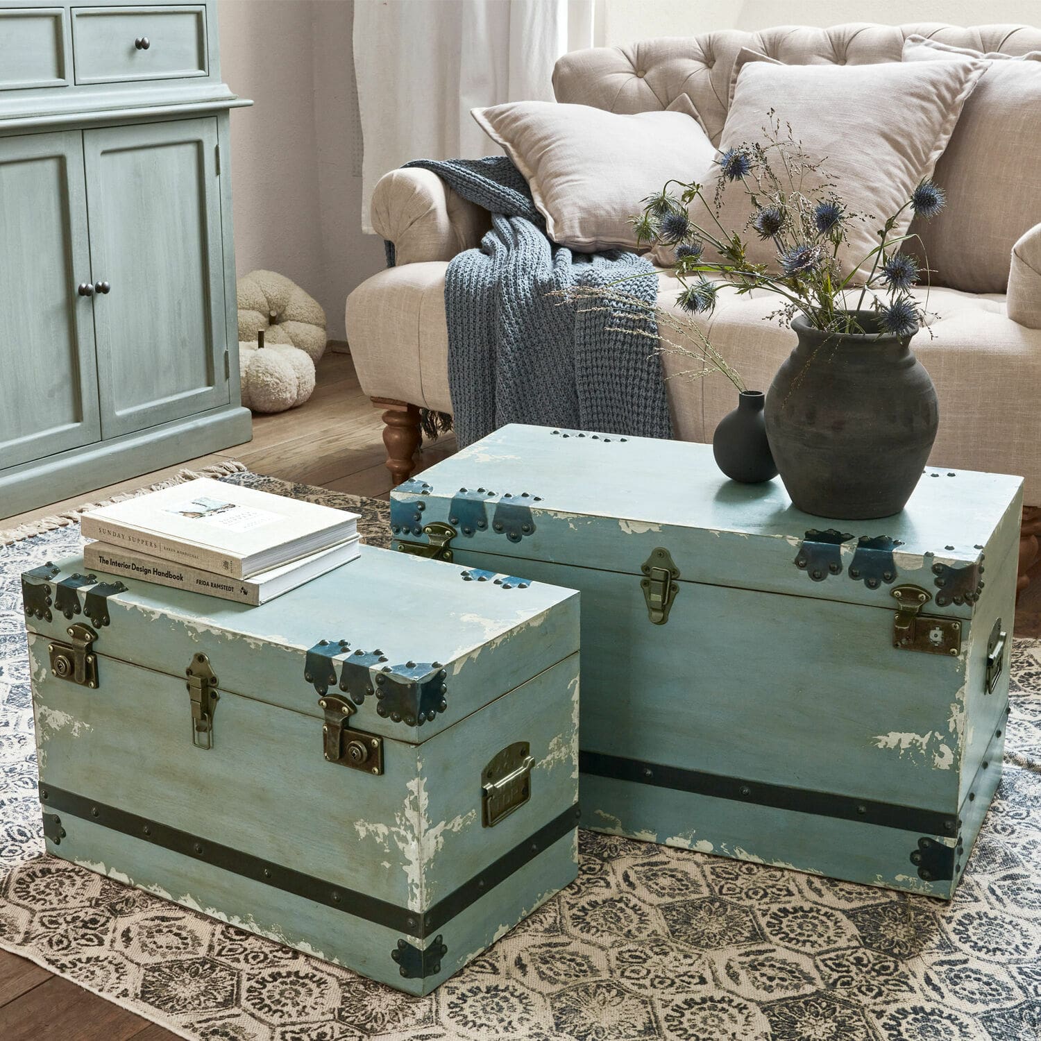 Truhe 2er Set Gorman Zwei blaue Holzkoffer mit Metallbeschlägen auf Teppich im Wohnzimmer mit beigem Sofa