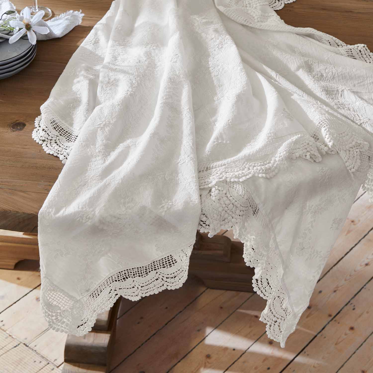 Weißer bestickter Tischläufer mit Spitzenrand auf Holztisch, elegante Tischdekoration