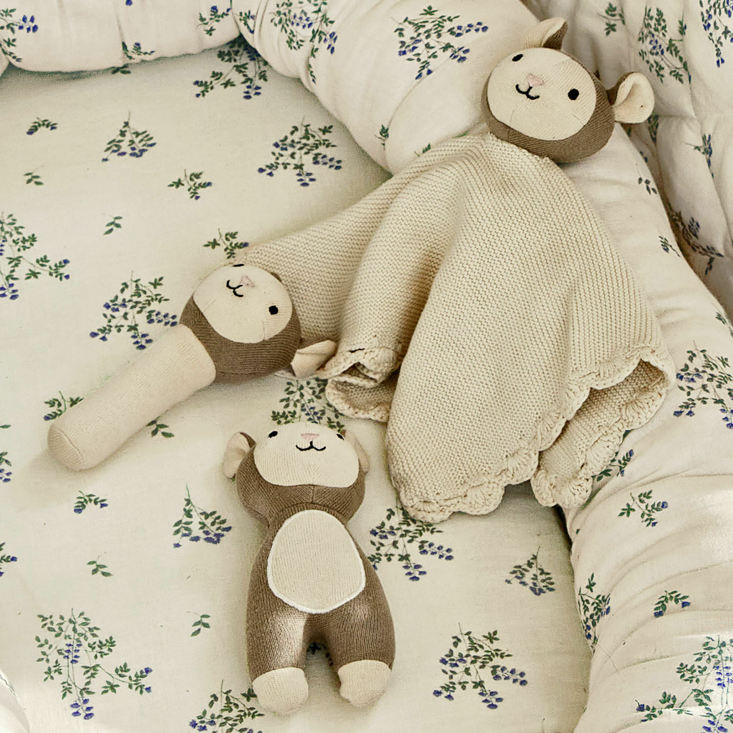Stofftier 3er Set Playfulo Set aus beigen und braunen Kuscheltieren auf geblümter Kinderbettwäsche