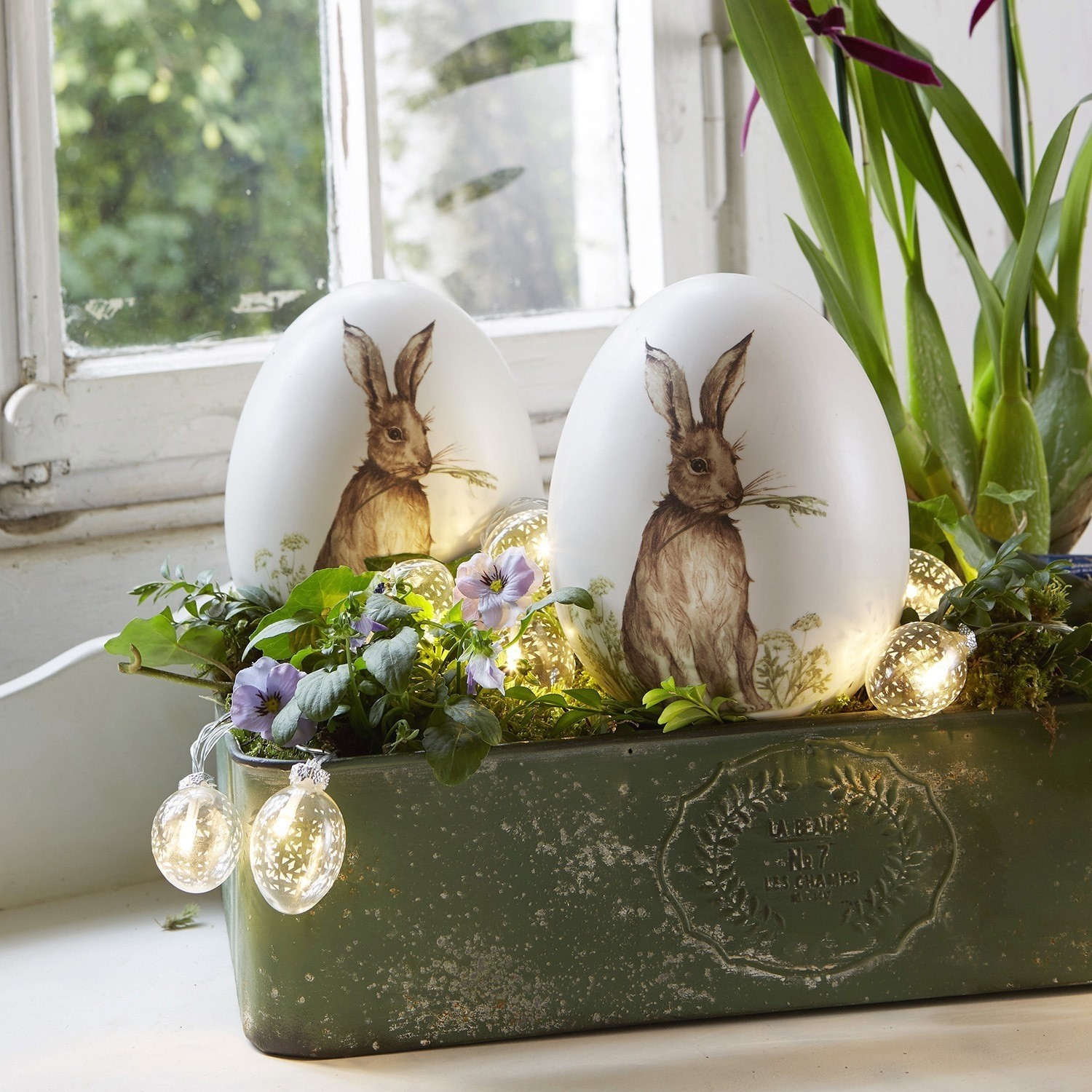 Osterei 2er Set Rubie Weiße Dekoeier mit Hasenmotiv in grünem Pflanzgefäß mit Blumen und LED-Lichterkette