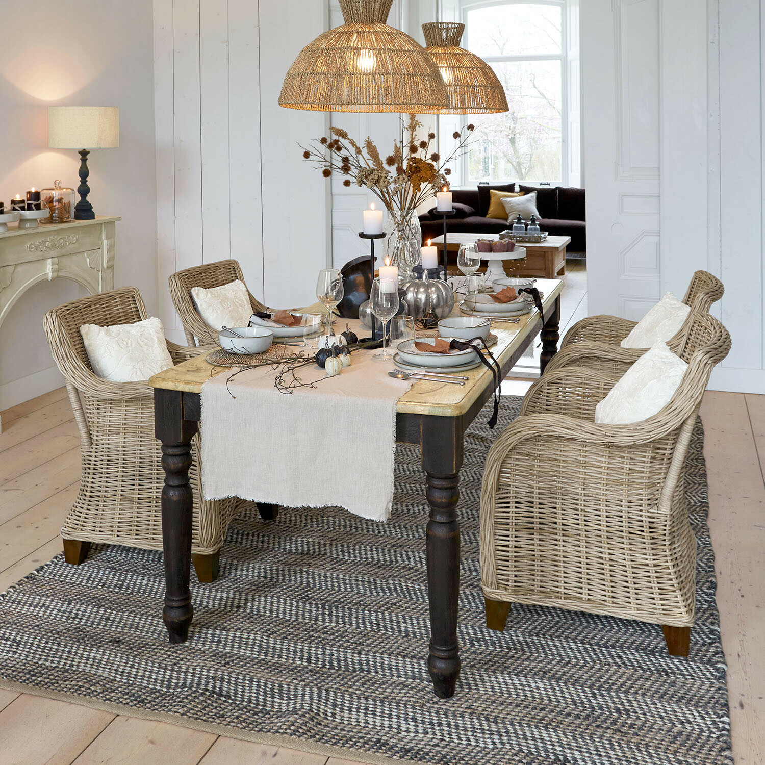 Tisch Mont Lisan Esszimmer mit Holztisch und naturfarbenen Rattanstühlen, Tischdekoration und Rattan-Hängelampen