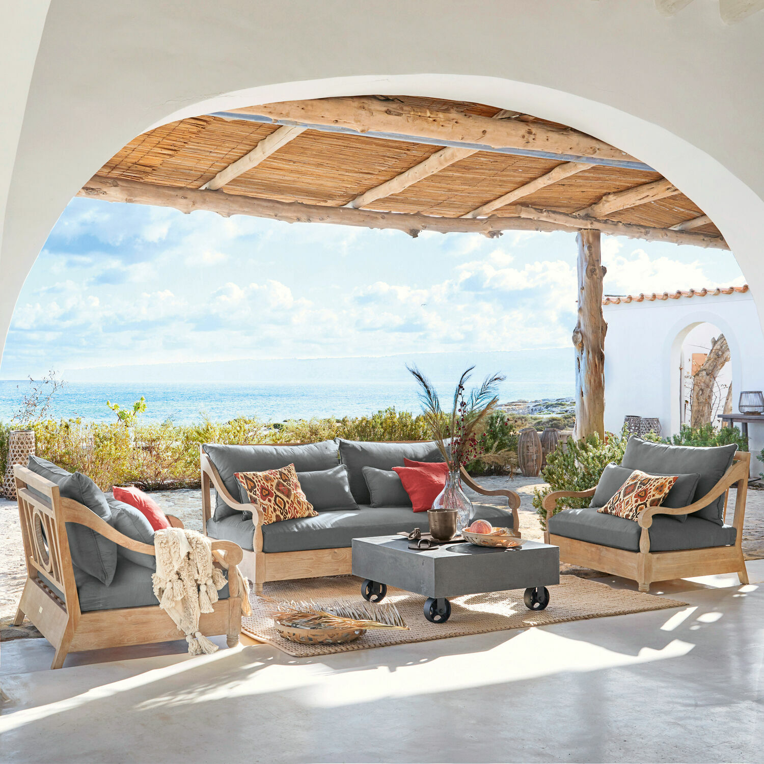 Sitzgruppe Montcassin Gartenmöbel-Set aus Holz mit grauen Polstern auf Terrasse mit Meerblick