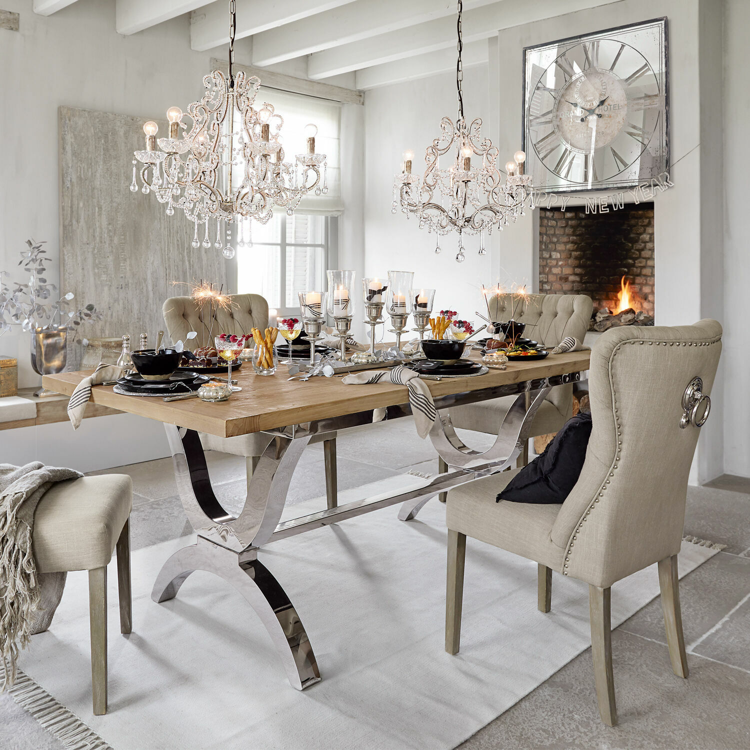 Tisch Grover Esszimmer mit Holztisch und beige gepolsterten Stühlen, Dekorationen und Kristall-Kronleuchtern