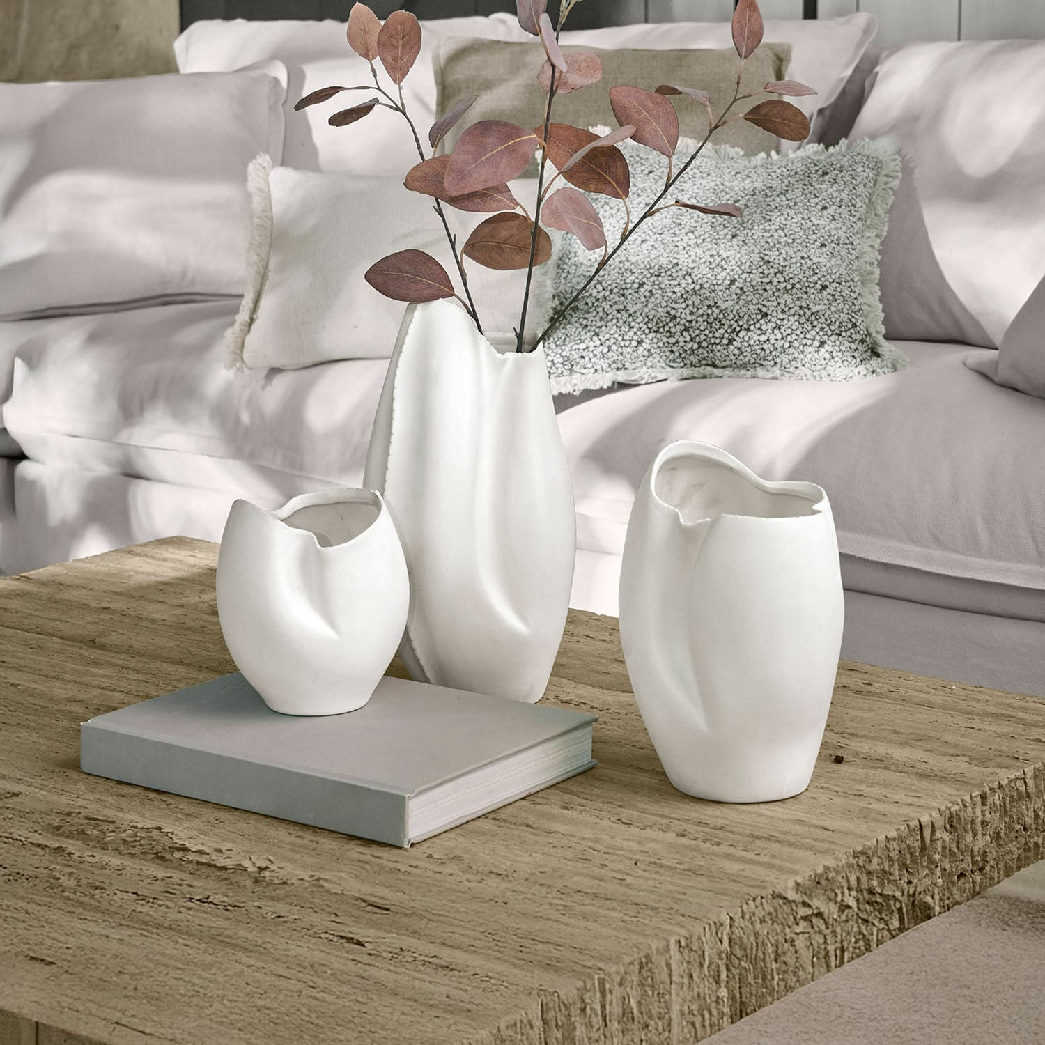 Vase 3er Set Kazimad Drei weiße Keramikvasen mit unregelmäßiger Form auf einem Holztisch im Wohnzimmer