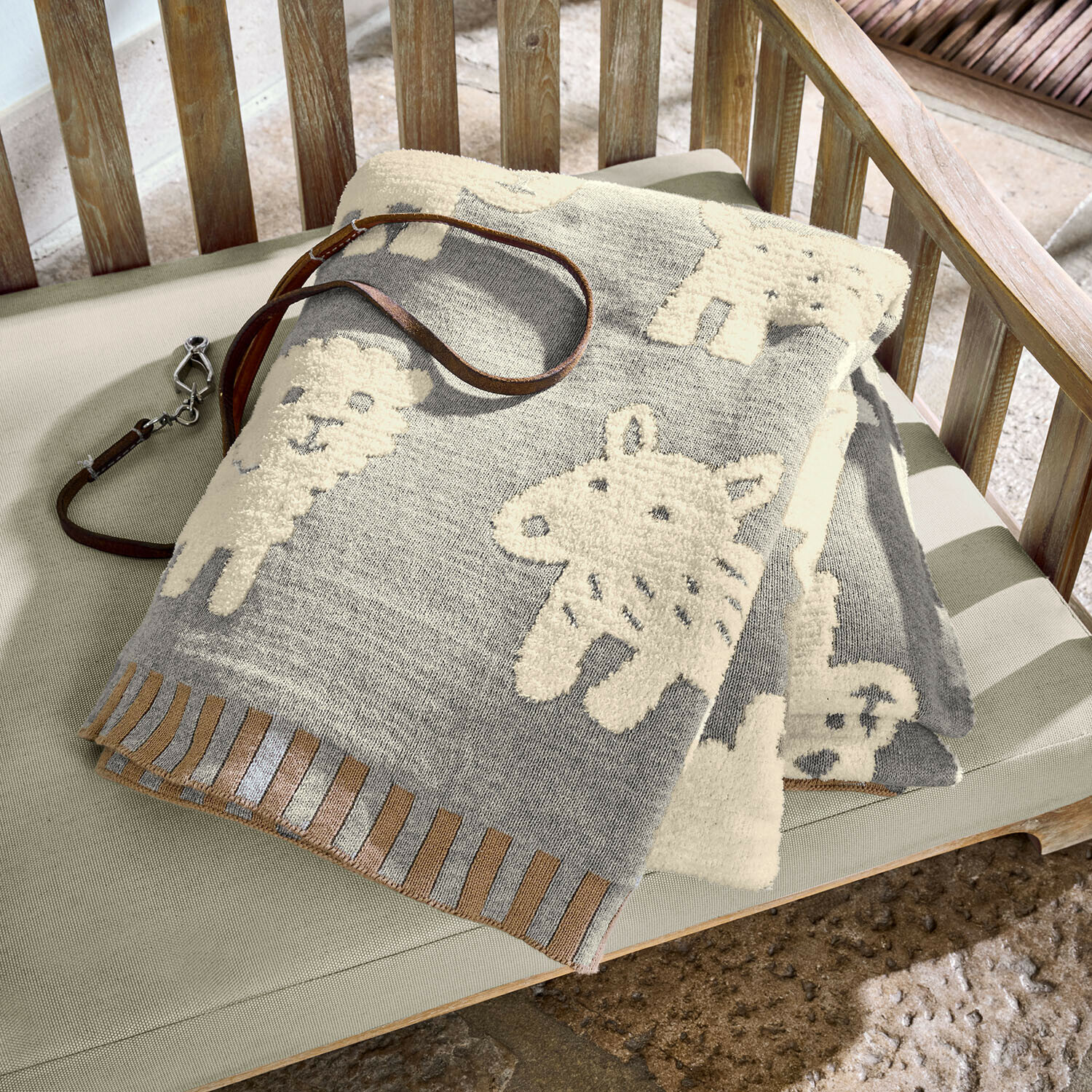 Hundedecke Fluffido Graue Baumwolldecke mit cremefarbenen Tiermotiven auf Holzbank, dekorativer Kuscheldecke