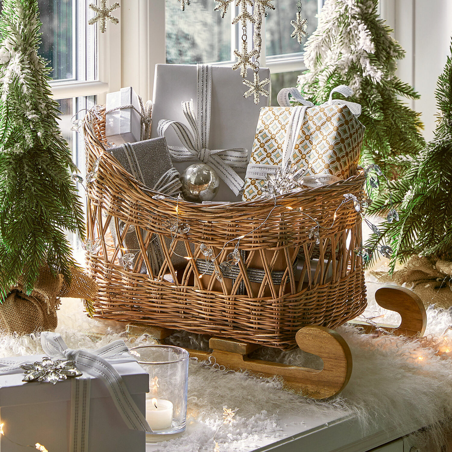 Deko-Schlitten Quileta Wikinger Schlitten aus Korbgeflecht mit Holzschlittenkufen, gefüllt mit silber-weißen Geschenkpaketen im Weihnachtsdekor