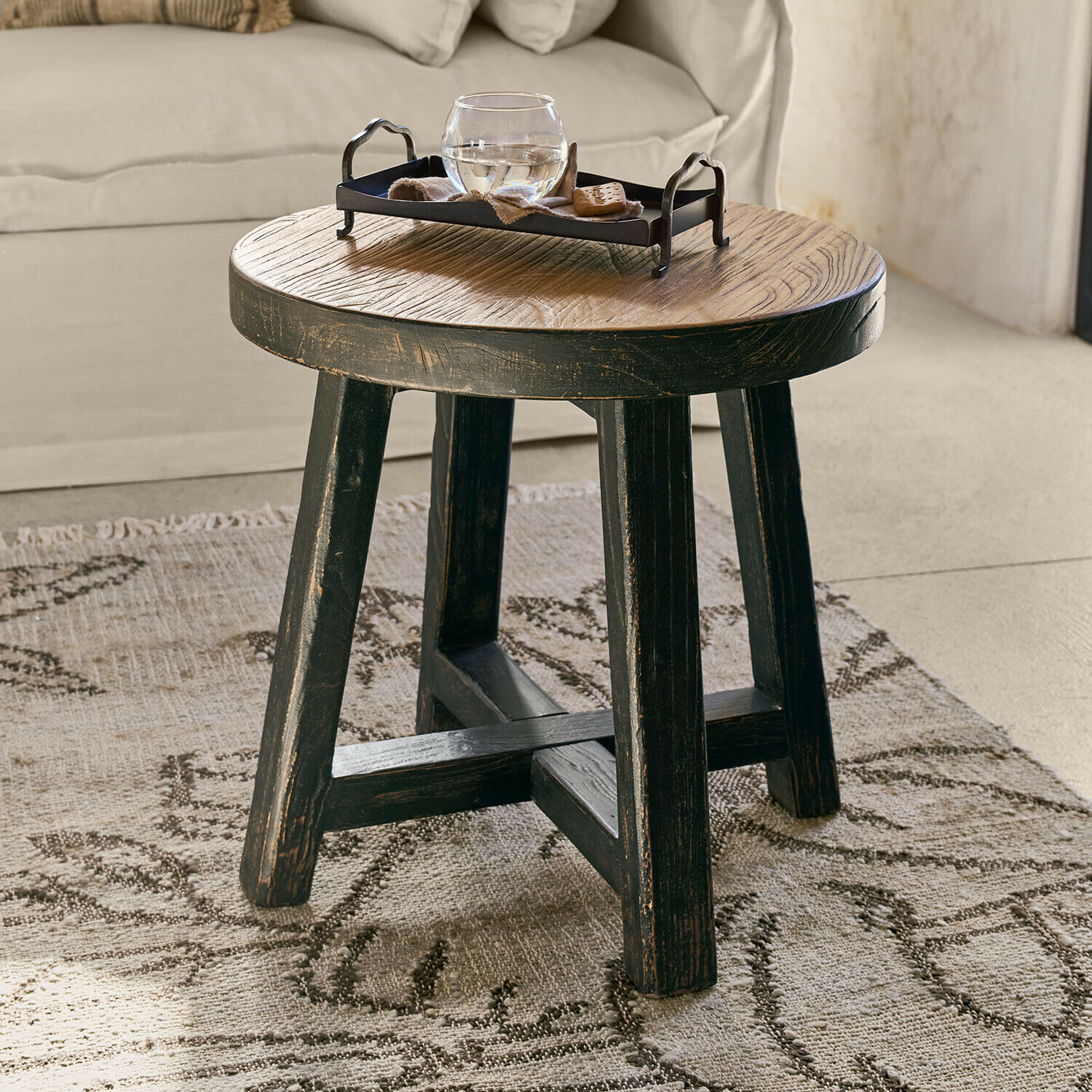 Runder Couchtisch aus Holz in Schwarz und Naturtönen auf Teppich im Wohnzimmer