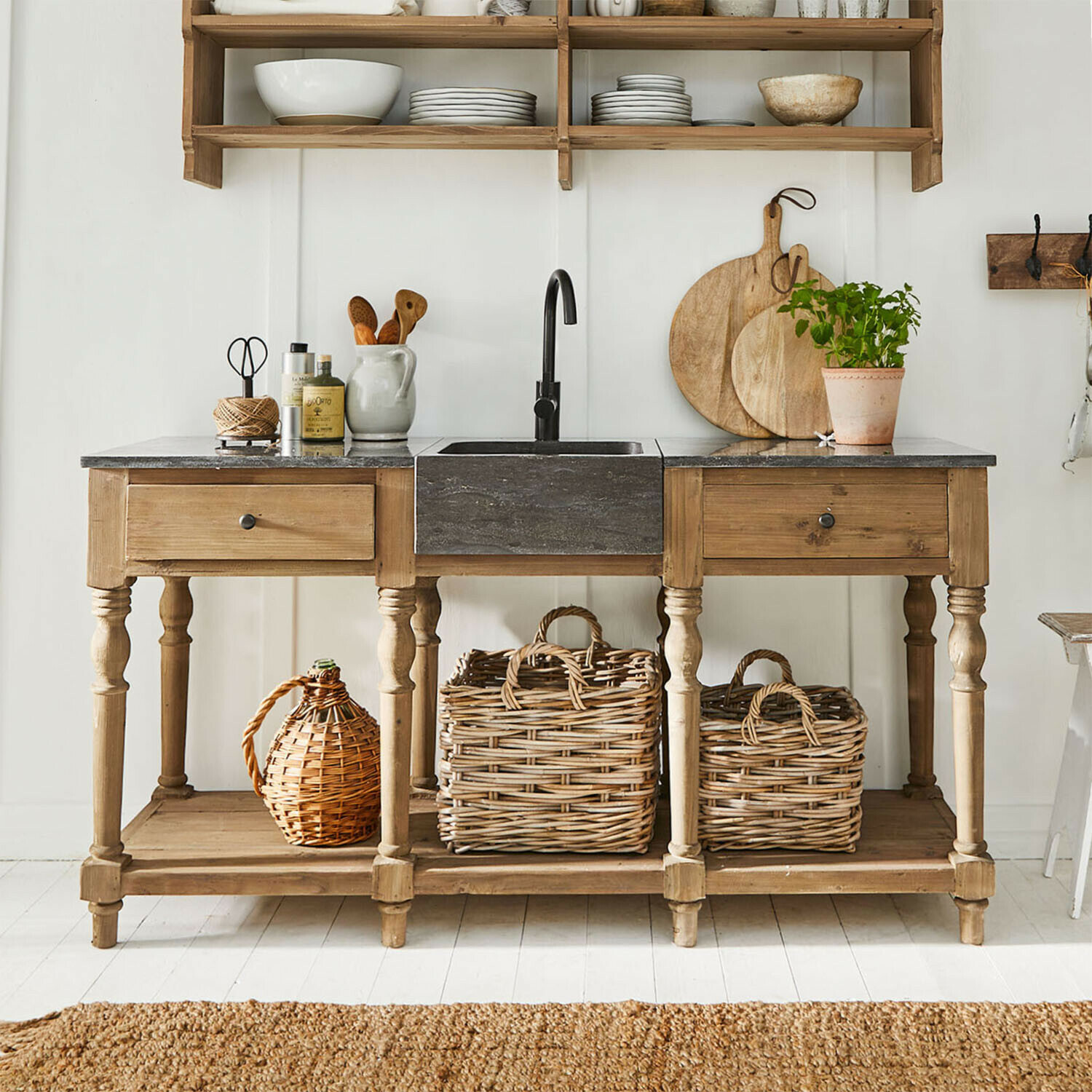 Holzküche mit schwarzem Steineinbauwaschbecken und Korb aus Weide, rustikaler Landhausstil