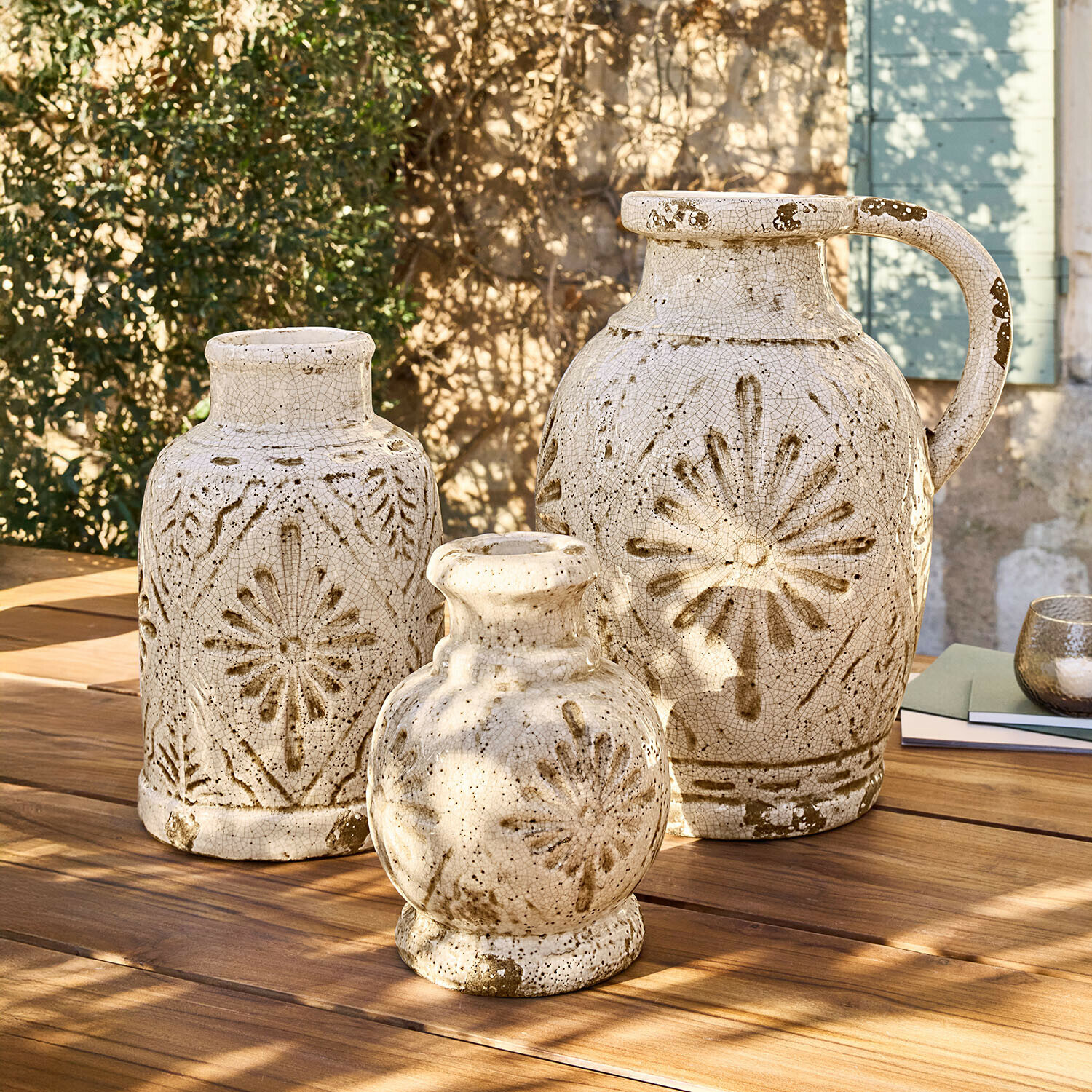 Vase 3er Set Orsémine Set aus drei cremefarbenen Keramikvasen mit braunen Mustern auf Holztisch im Außenbereich