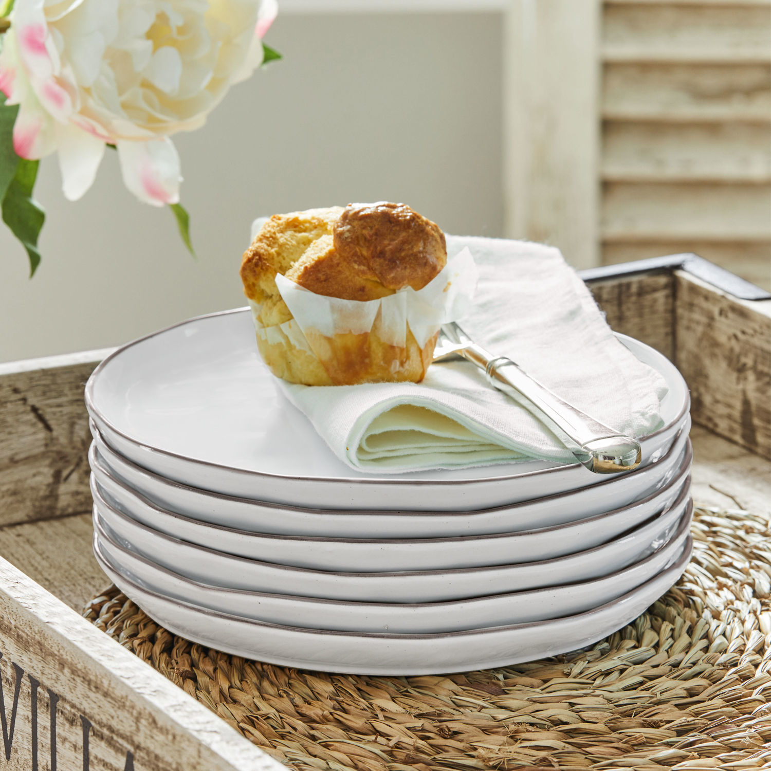 Dessertteller 6er Set Biarré Set aus weißen Keramiktellern mit Muffin und silbernem Messer auf Leinenserviette
