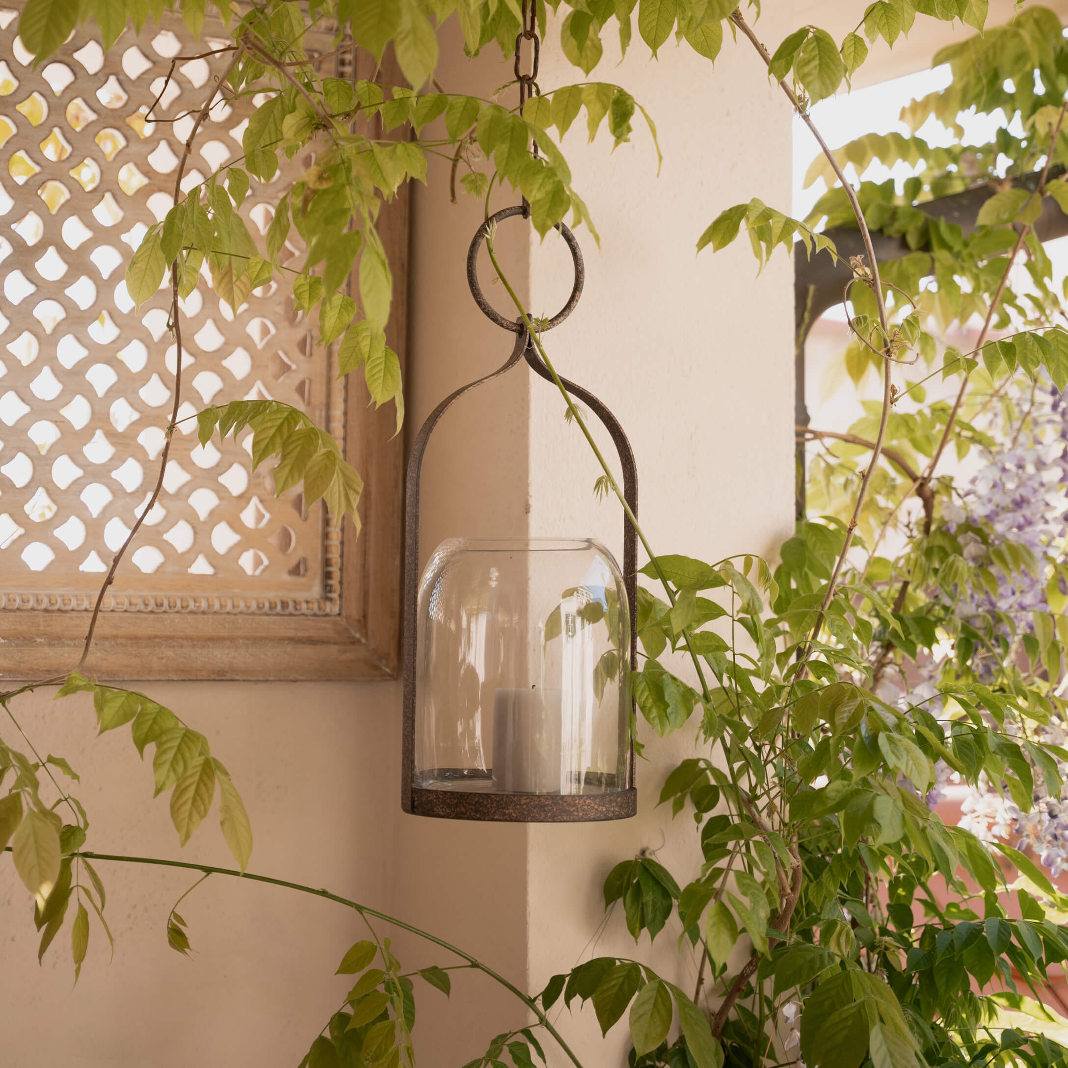 Hängender Laternenhalter aus Metall und Glas mit weißer Kerze, rustikale Gartendekoration