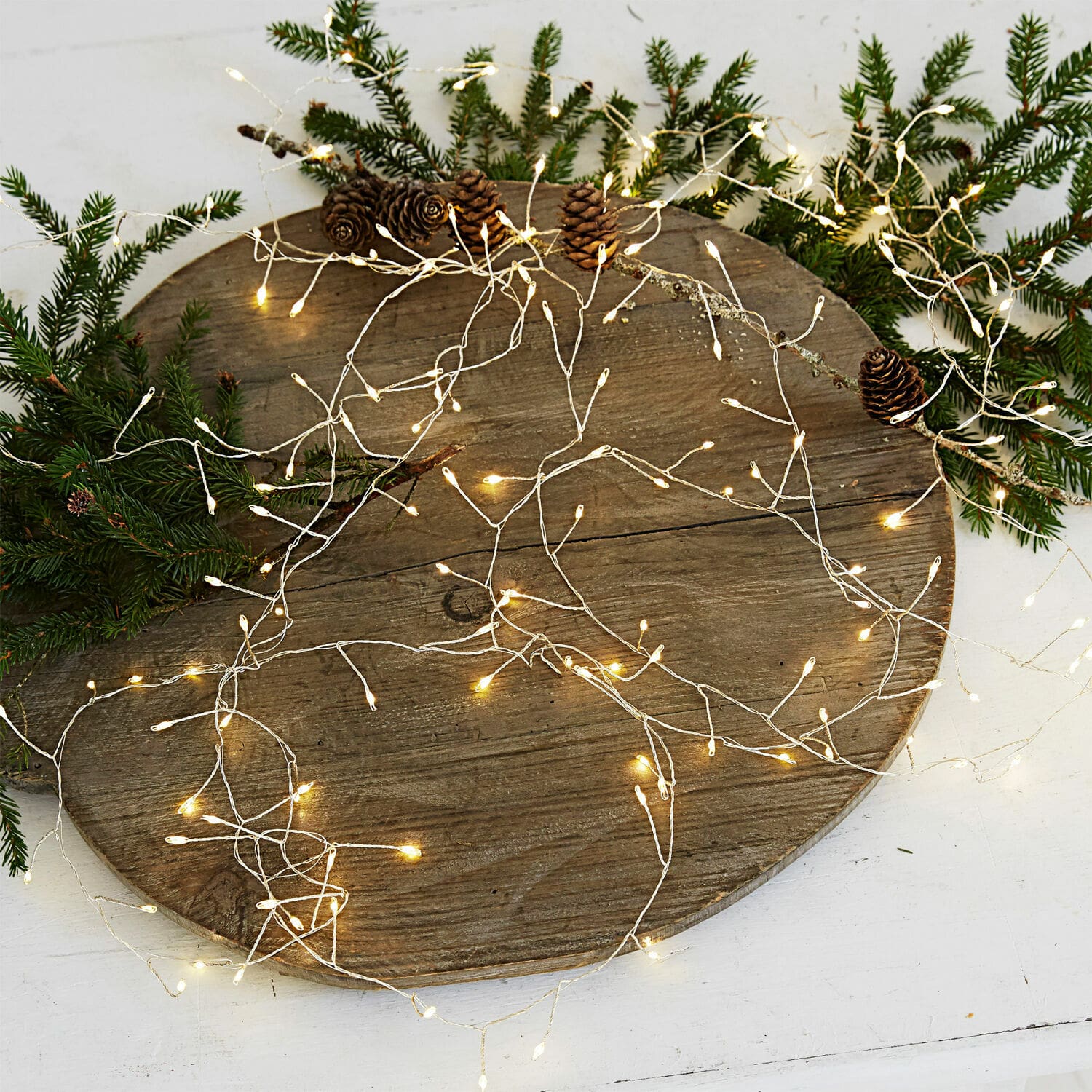Lichterkette Minas Feine warmweiße LED-Lichterkette auf silbernem Draht mit Tannenzapfen und grünen Tannenzweigen
