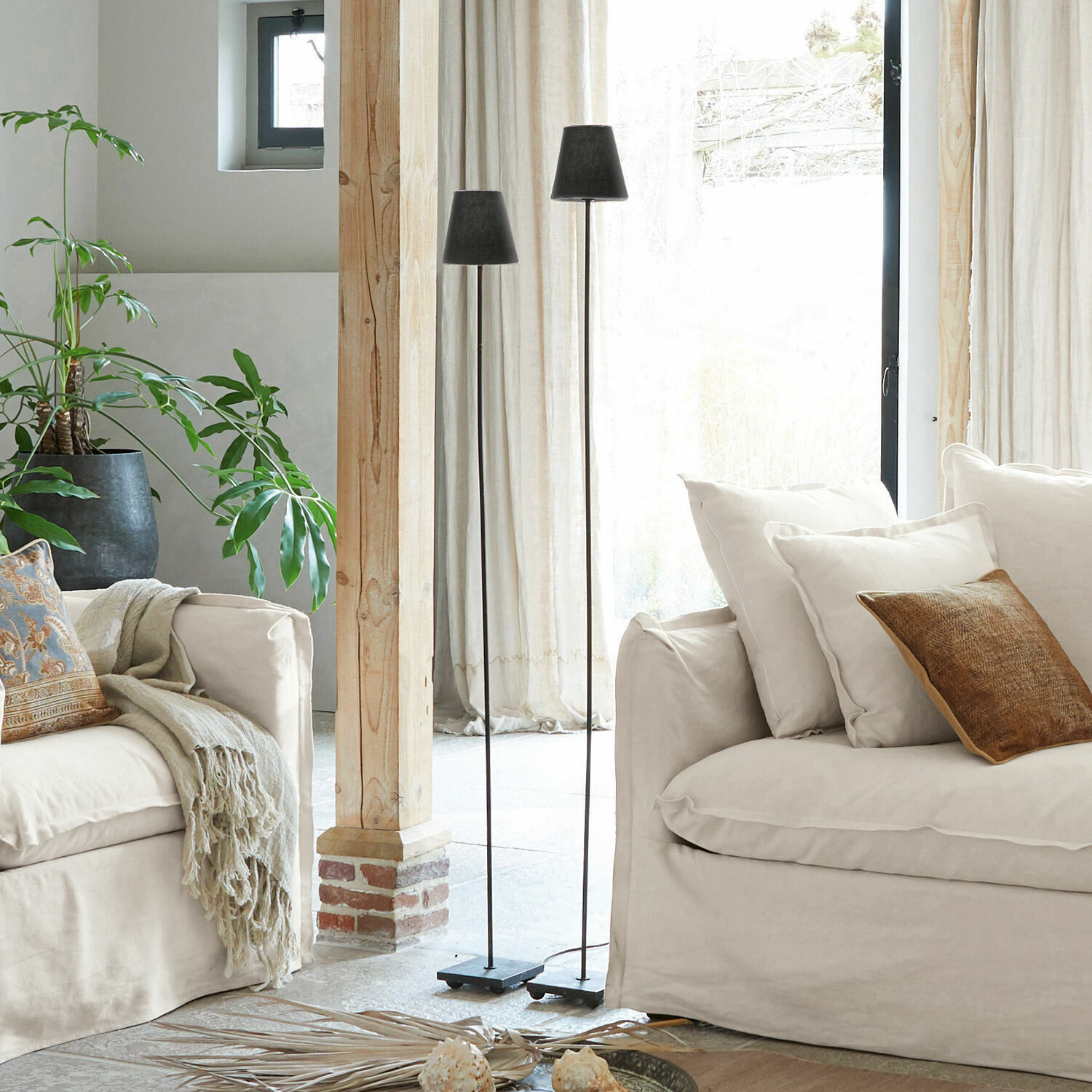 Stehlampe 2er Set Tacoma Zwei schwarze Metall-Stehlampen im hellen Wohnzimmer mit beigem Sofa und grüner Pflanze