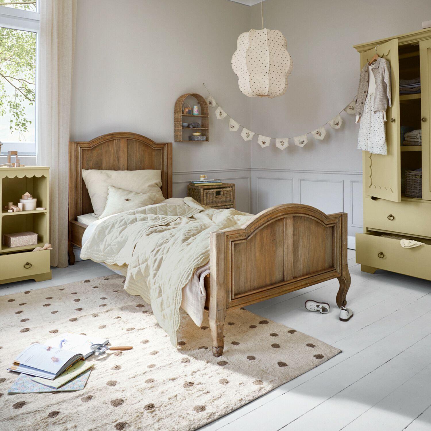 Einzelbett Rêverine Kinderbett aus Holz mit beiger Bettwäsche und cremefarbenem Teppich in hellem Kinderzimmer