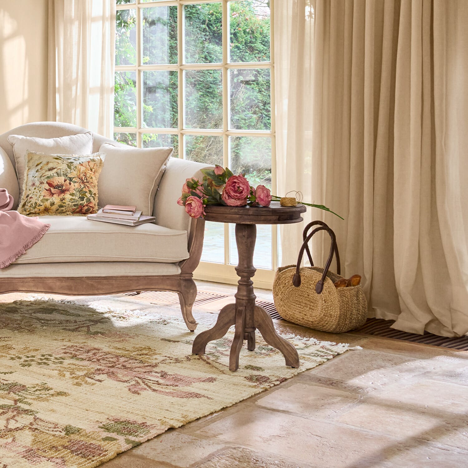 Gemütliches Wohnzimmer mit beigem Sofa, hölzernem Beistelltisch und Blumen auf floralem Teppich