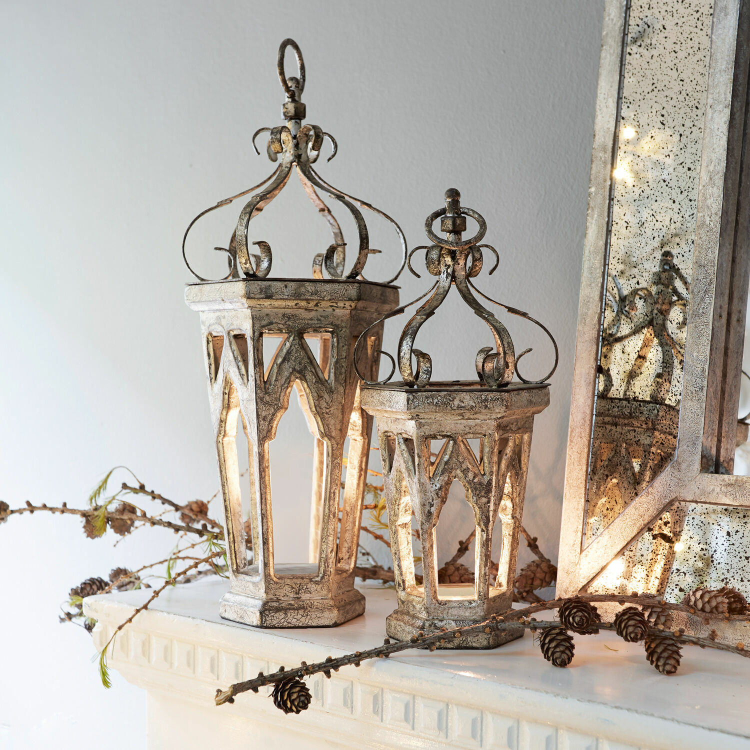 Deko-Objekt 2er Set Morvant Dekorative Metalllaternen im Vintage-Stil in antik-silber auf Kaminsims mit Kiefernzapfen