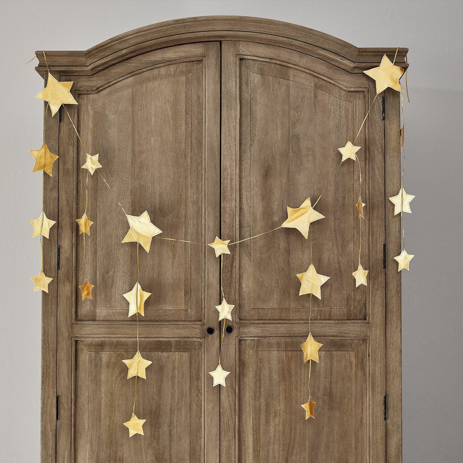 Girlande Étoilin Goldene Stern-Girlande an einem Holzschrank, festliche Wohnraumdekoration für Weihnachten