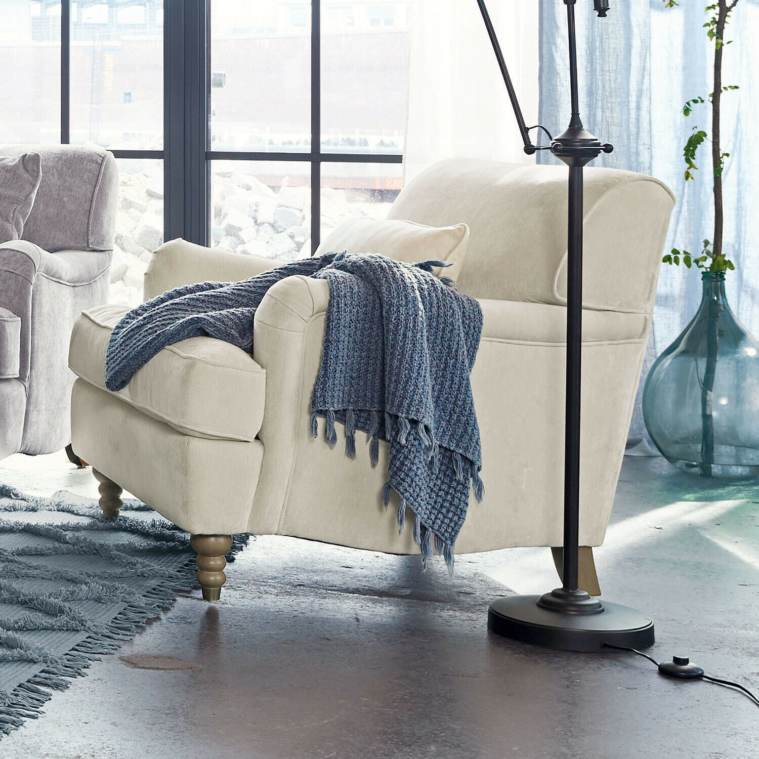 Beige bezogener Sessel mit Holzbeinen und blauem Strickplaid in modernem Wohnzimmer
