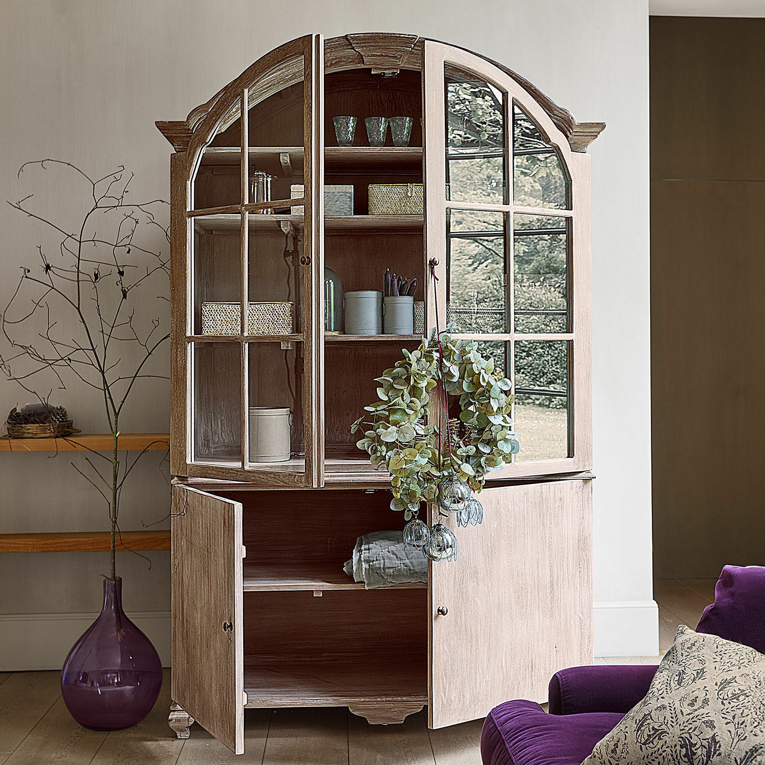 Schrank Périmonde Helle Holzvitrine mit Glastüren und dekorativem Kranz, elegantes Wohnzimmermöbel