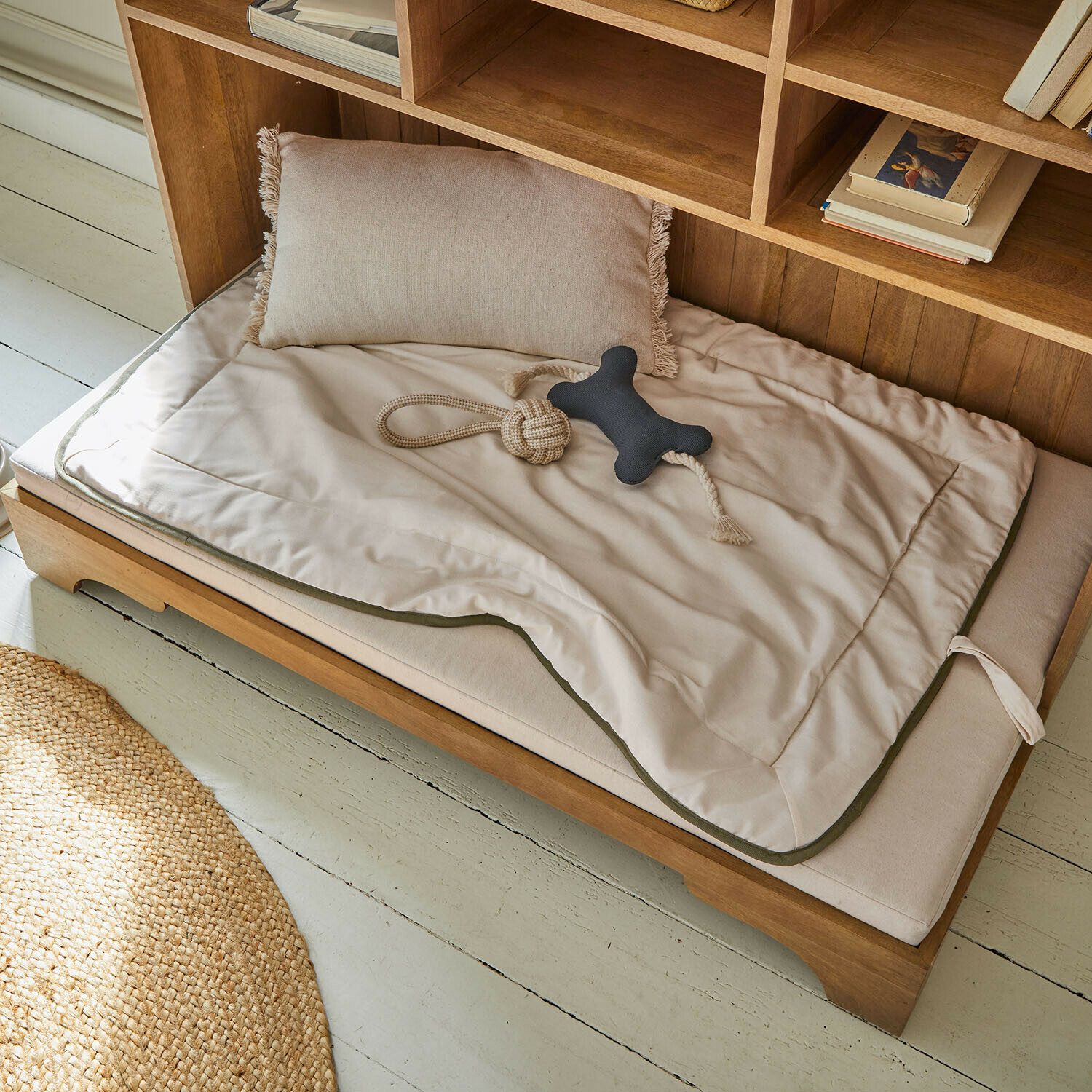 Haustiermatte Dunelyn Beige Matte und Kissen auf Holz-Hundebett mit Seilspielzeug und schwarzem Knochen