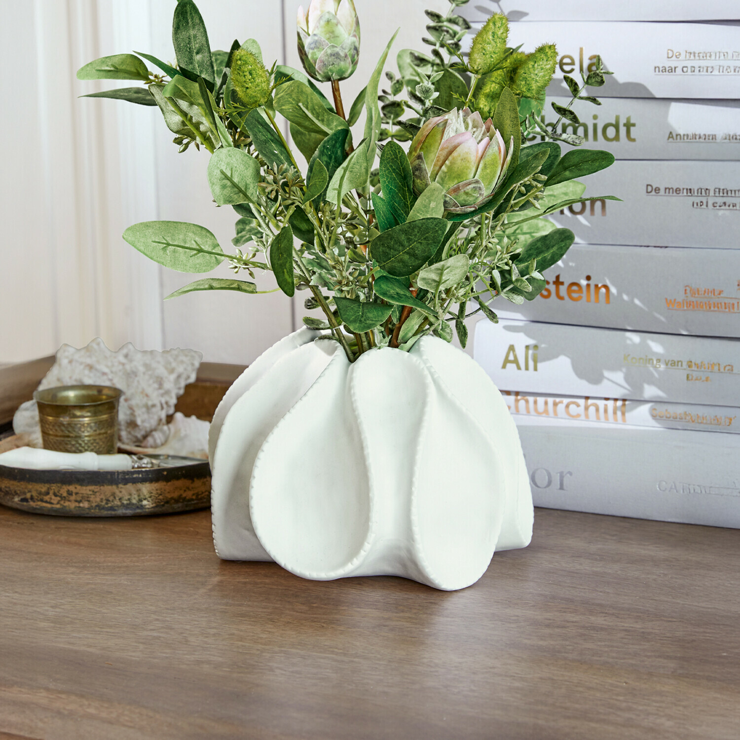 Deko-Vase Dollon Weiße Keramikvase mit grünen Blättern und dekorativen Blüten auf Holztisch