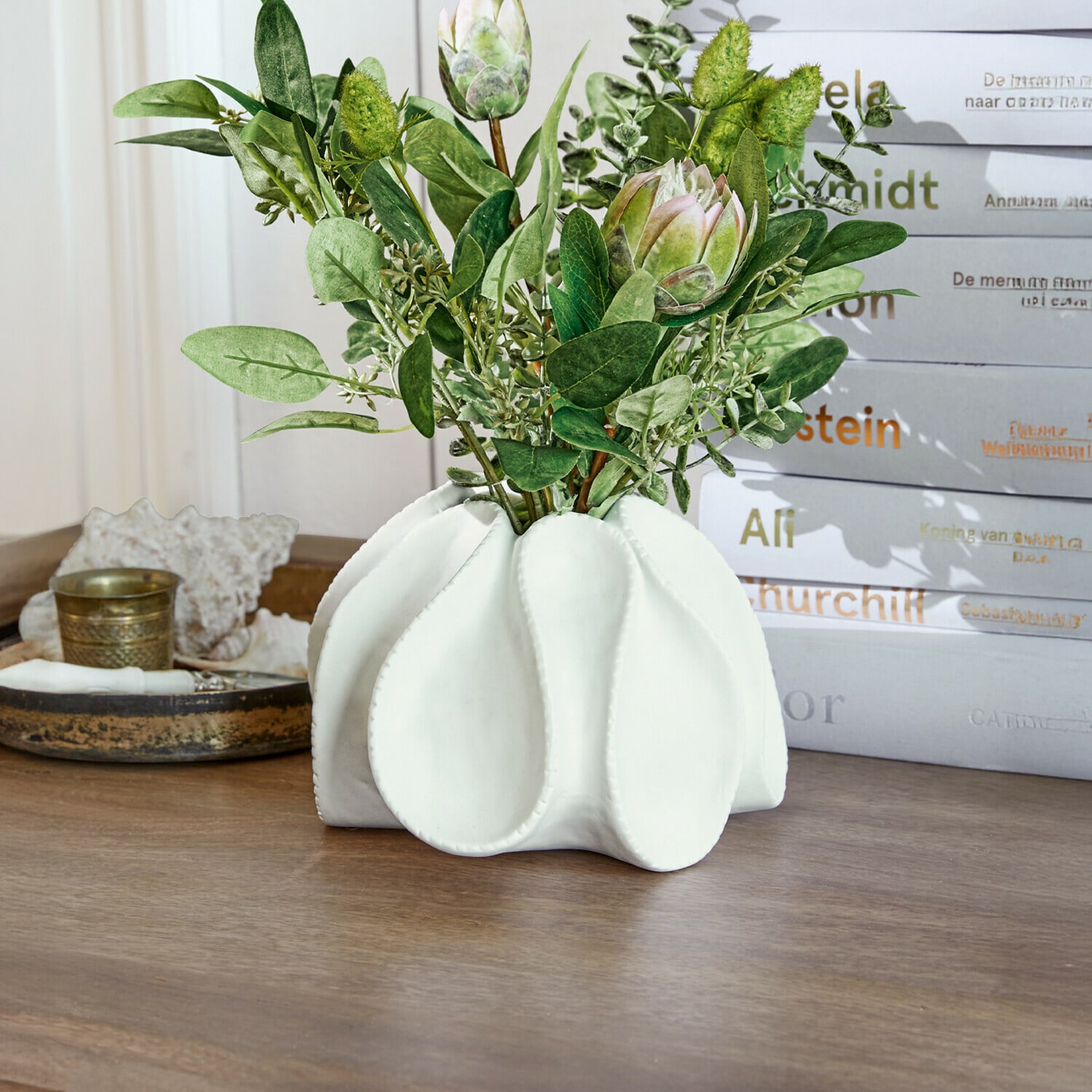 Deko-Vase Dollon Weiße Keramikvase mit grünen Blättern und dekorativen Blüten auf Holztisch