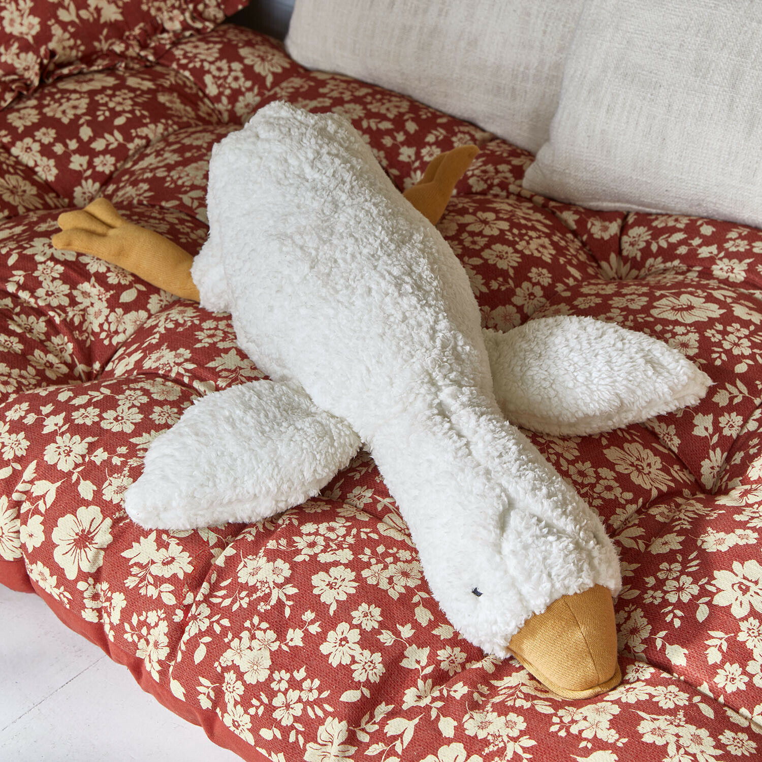 Stofftier Tillyboo Weiches Plüschspielzeug Gans in Weiß und Gelb auf rotem Kissen mit Blumenmuster