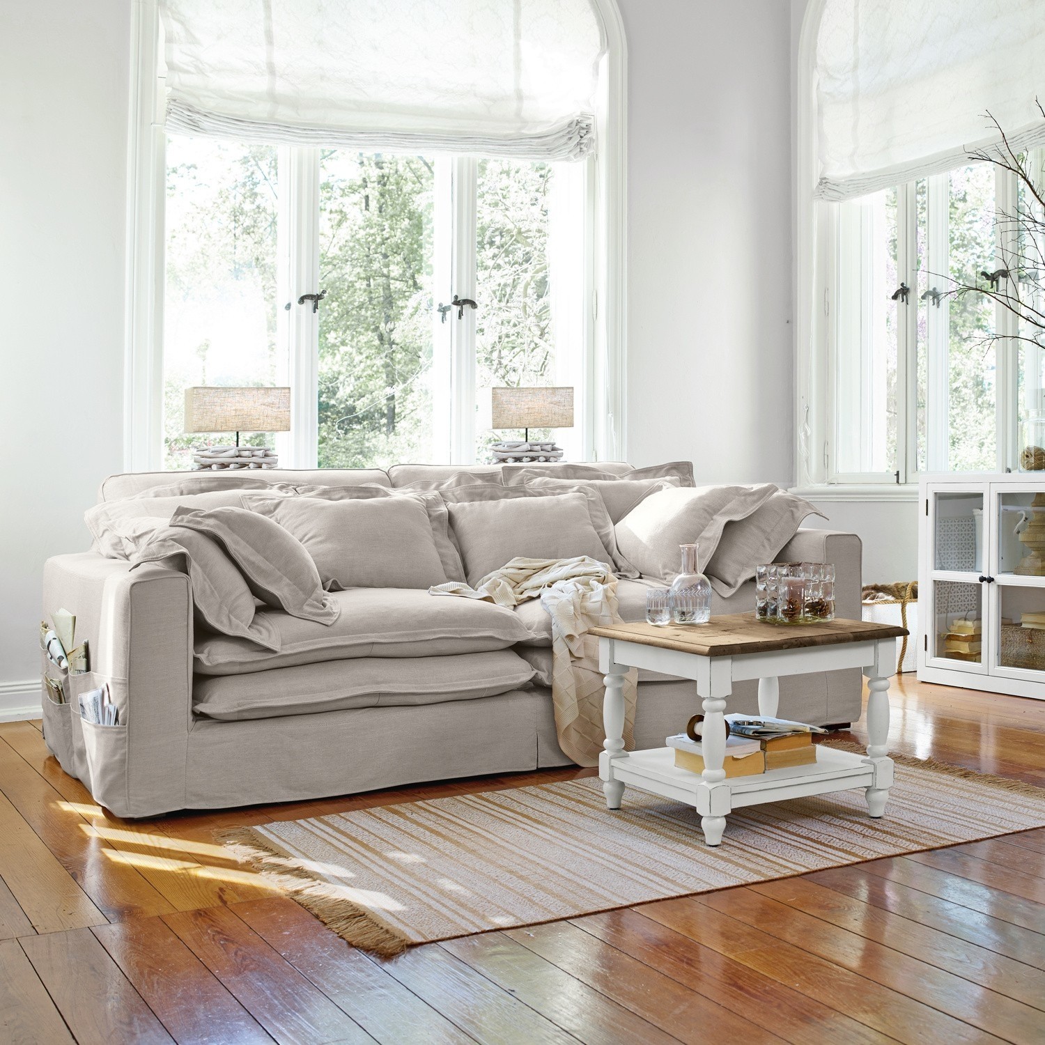 Sofa Terell Beiges Stoffsofa mit Kissen und weißem Couchtisch auf Holzboden in hellem Wohnzimmer