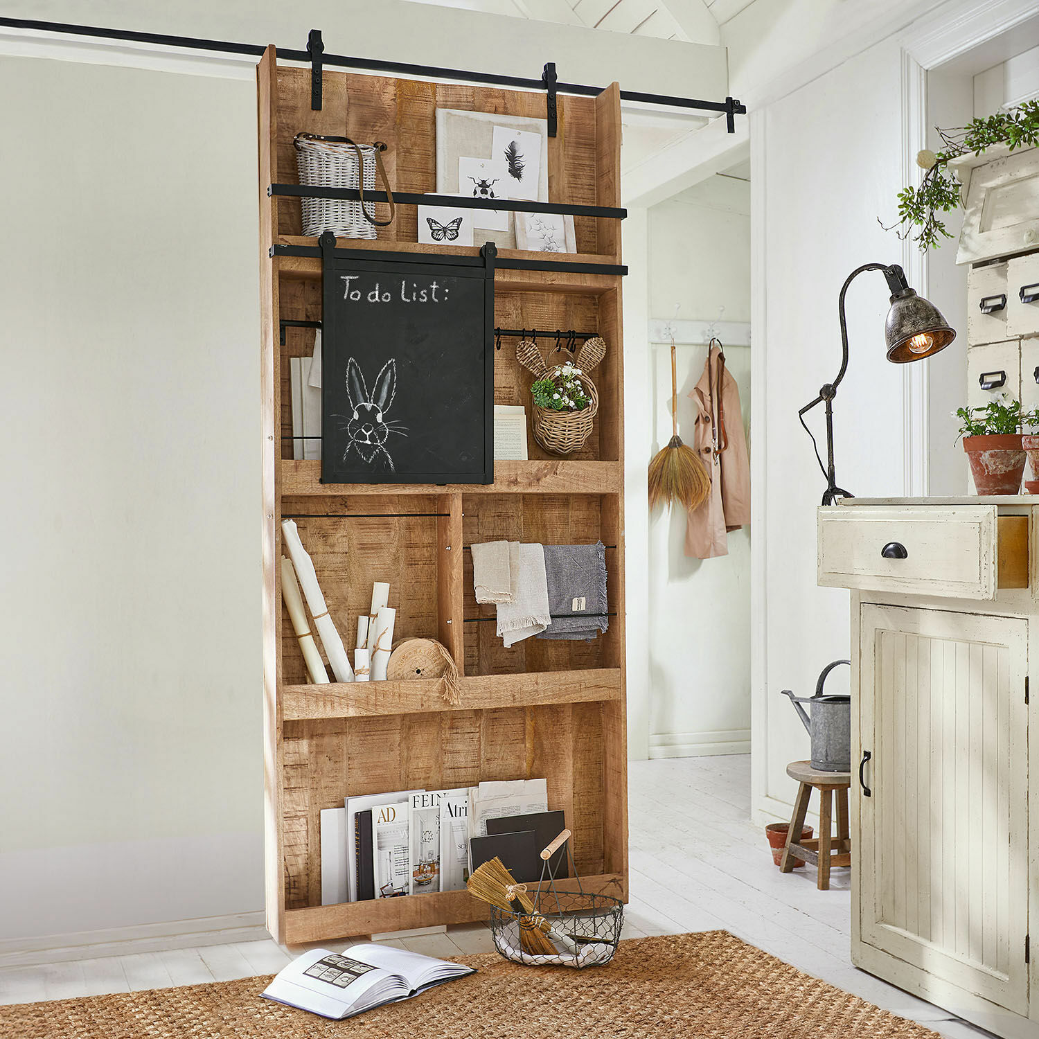 Schiebetür Vulmont Holzregal mit Kreidetafel und Dekorationen in hellem Raum mit Juteteppich
