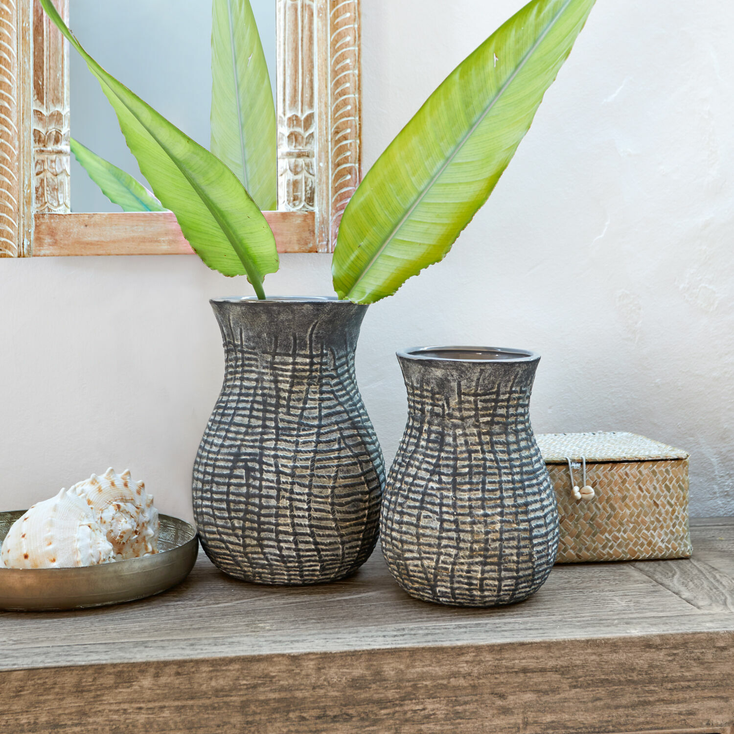 Vase 2er Set Fahrid Zwei graue Keramikvasen mit strukturiertem Muster auf Holztisch mit grünen Blättern dekoriert