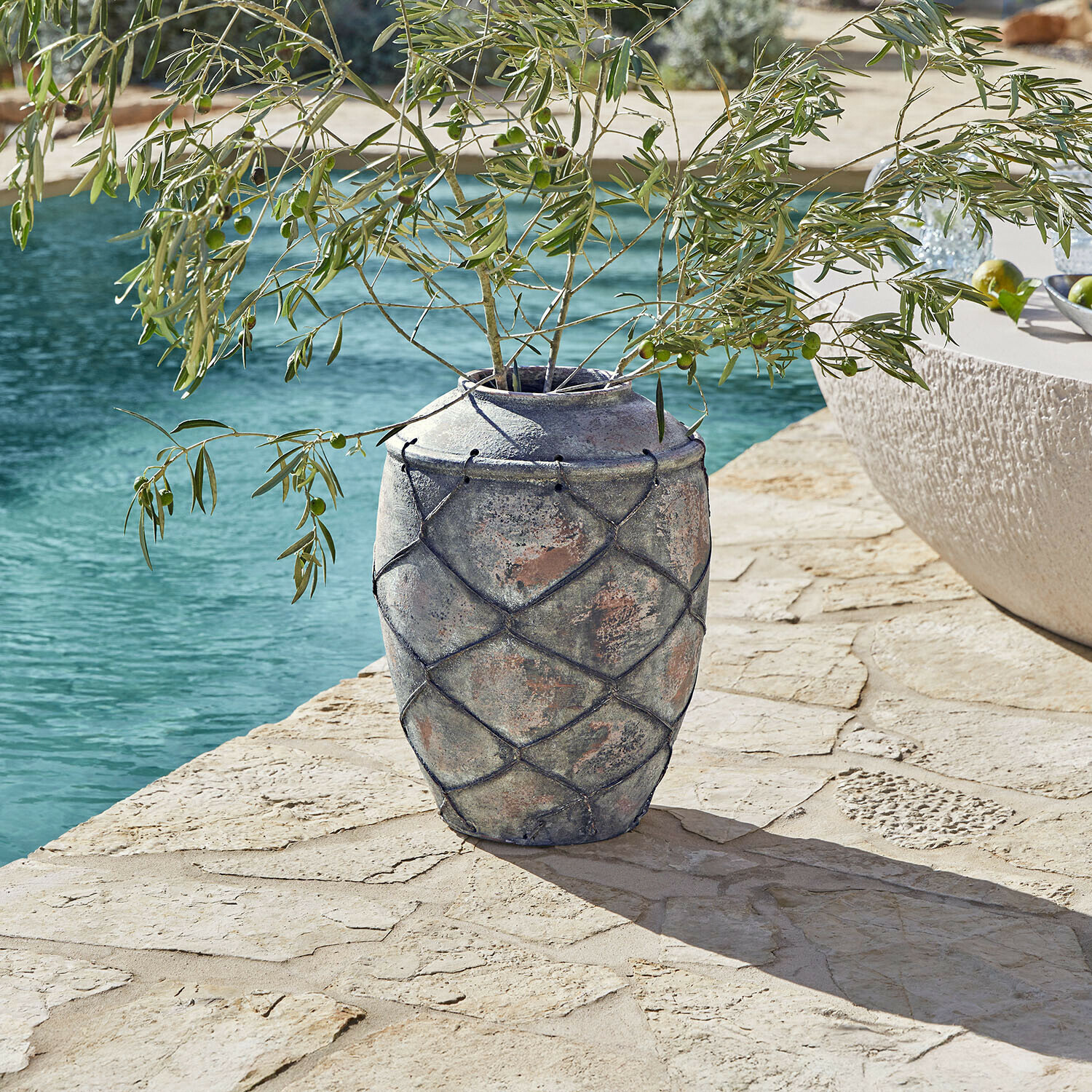 Vase Deloriva Große graue Keramikvase mit Netzdekor auf Steinterrasse neben Pool mit Olivenzweigen