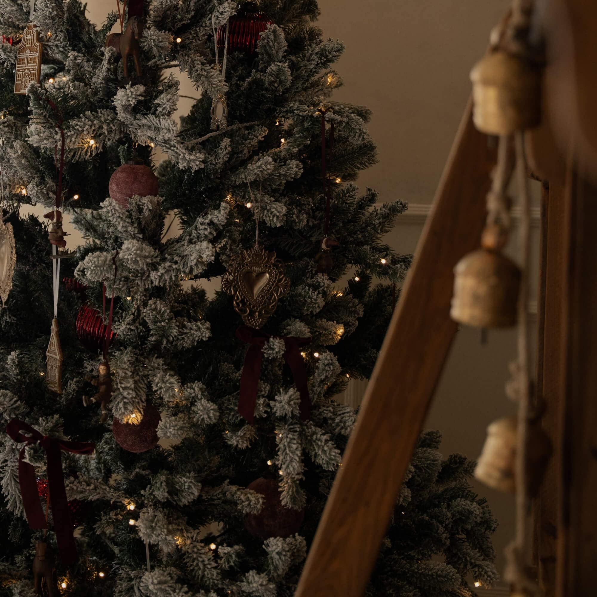 Künstlicher Weihnachtsbaum mit schneebedeckten Zweigen, roten Kugeln und LED-Lichtern