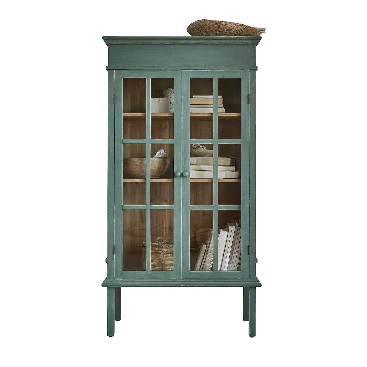 Grüner Holzvitrinenschrank mit Glastüren und Regalen mit Büchern und Dekorationen