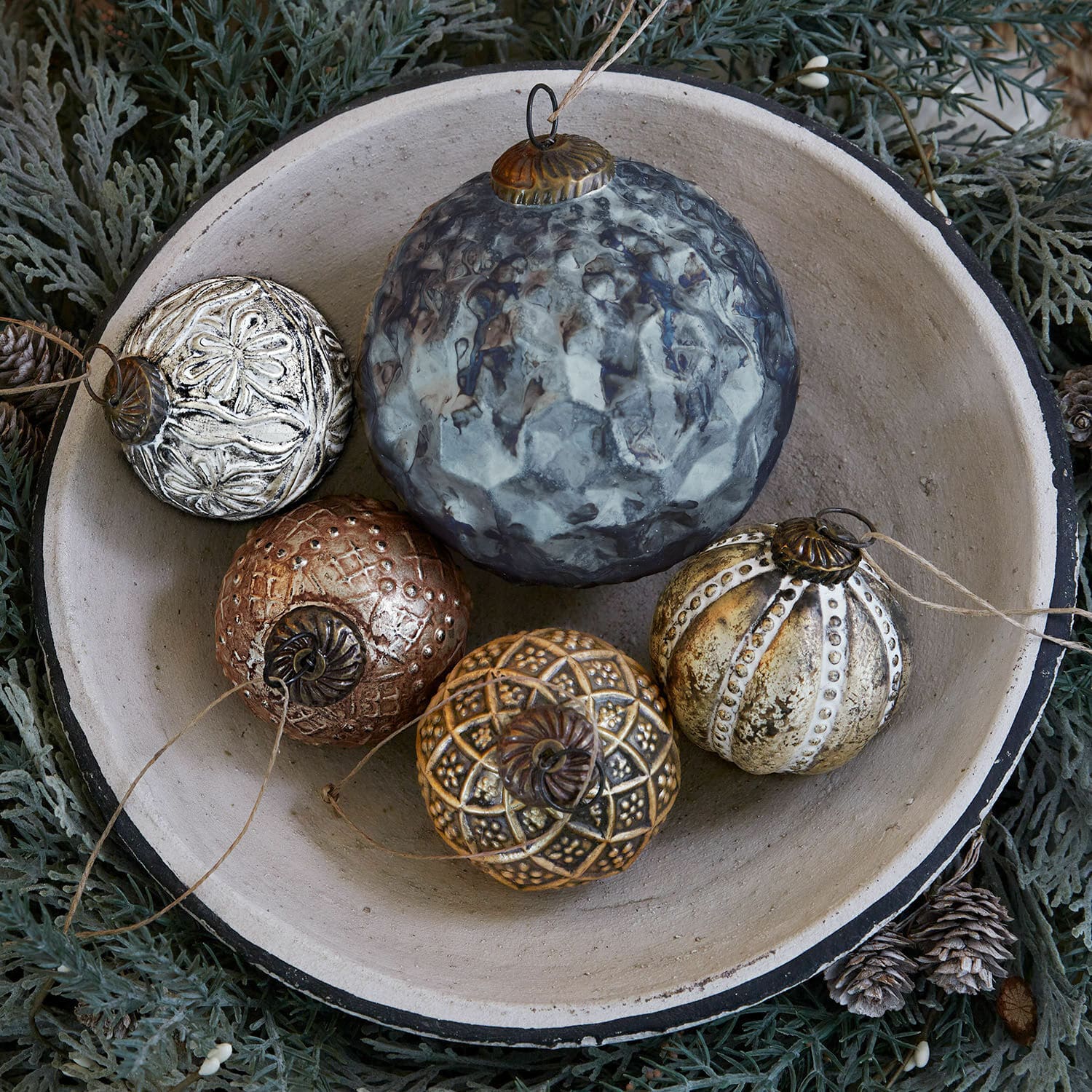 Weihnachtsschmuck 5er Set Jilian Dekorative Weihnachtskugeln aus Metall in verschiedenen Farben in Keramikschale auf grünem Hintergrund