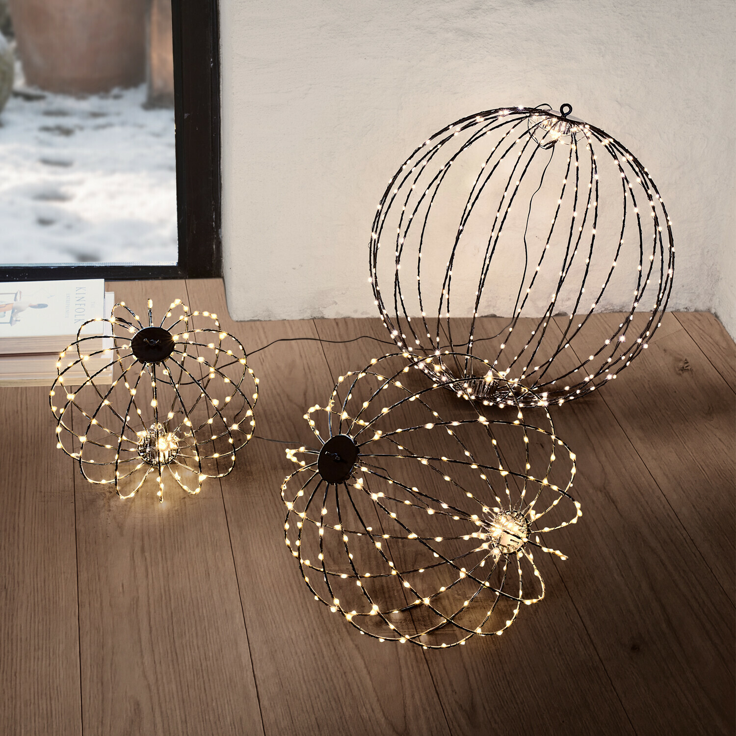 LED-Kugel 3er Set Brilliante Zwei dekorative LED-Lichtkugeln in warmweiß auf dem Boden eines modernen Wohnzimmers