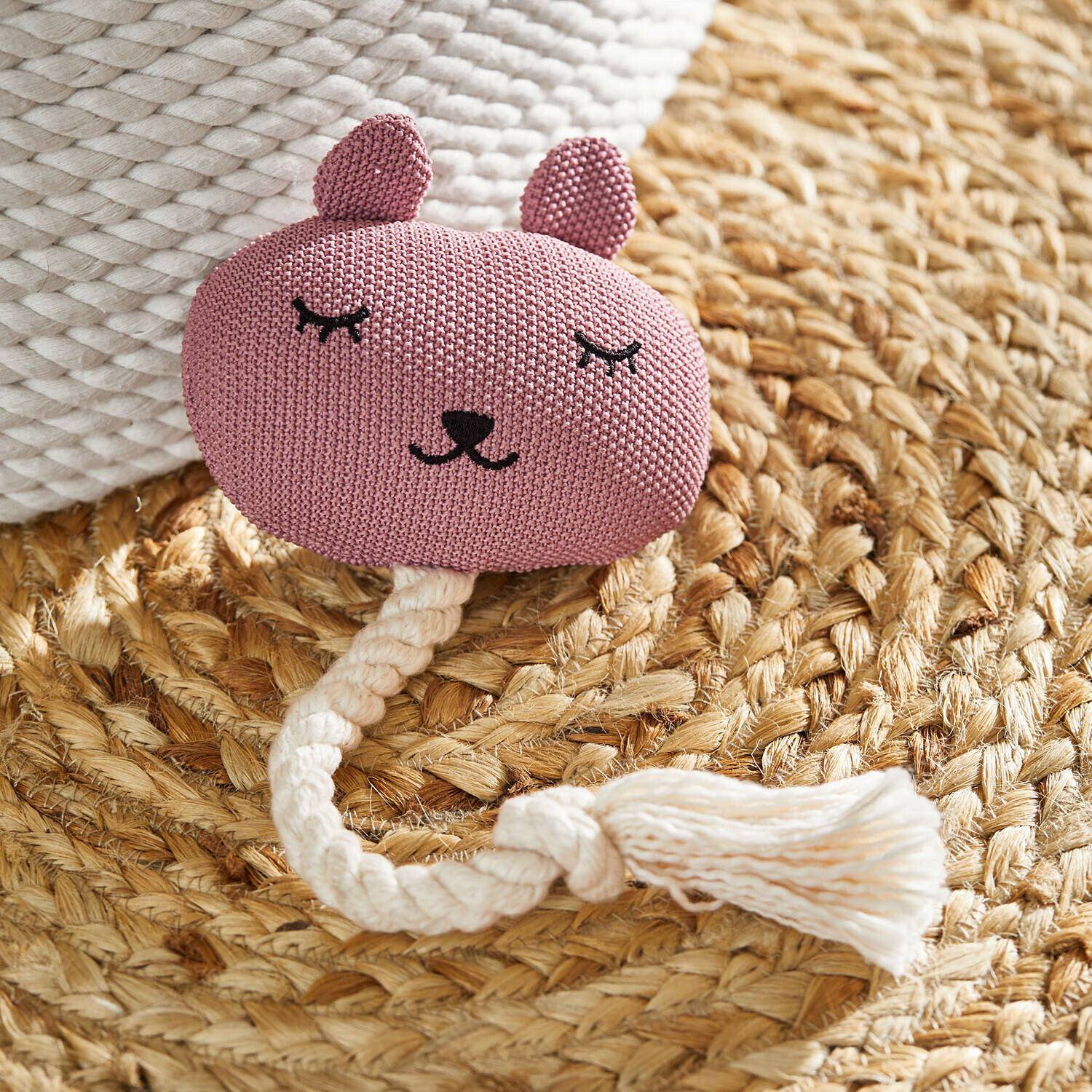 Katzenspielzeug Miezmo Rosa gestricktes Tier-Spielzeug mit weißem Seil auf geflochtenem Naturteppich