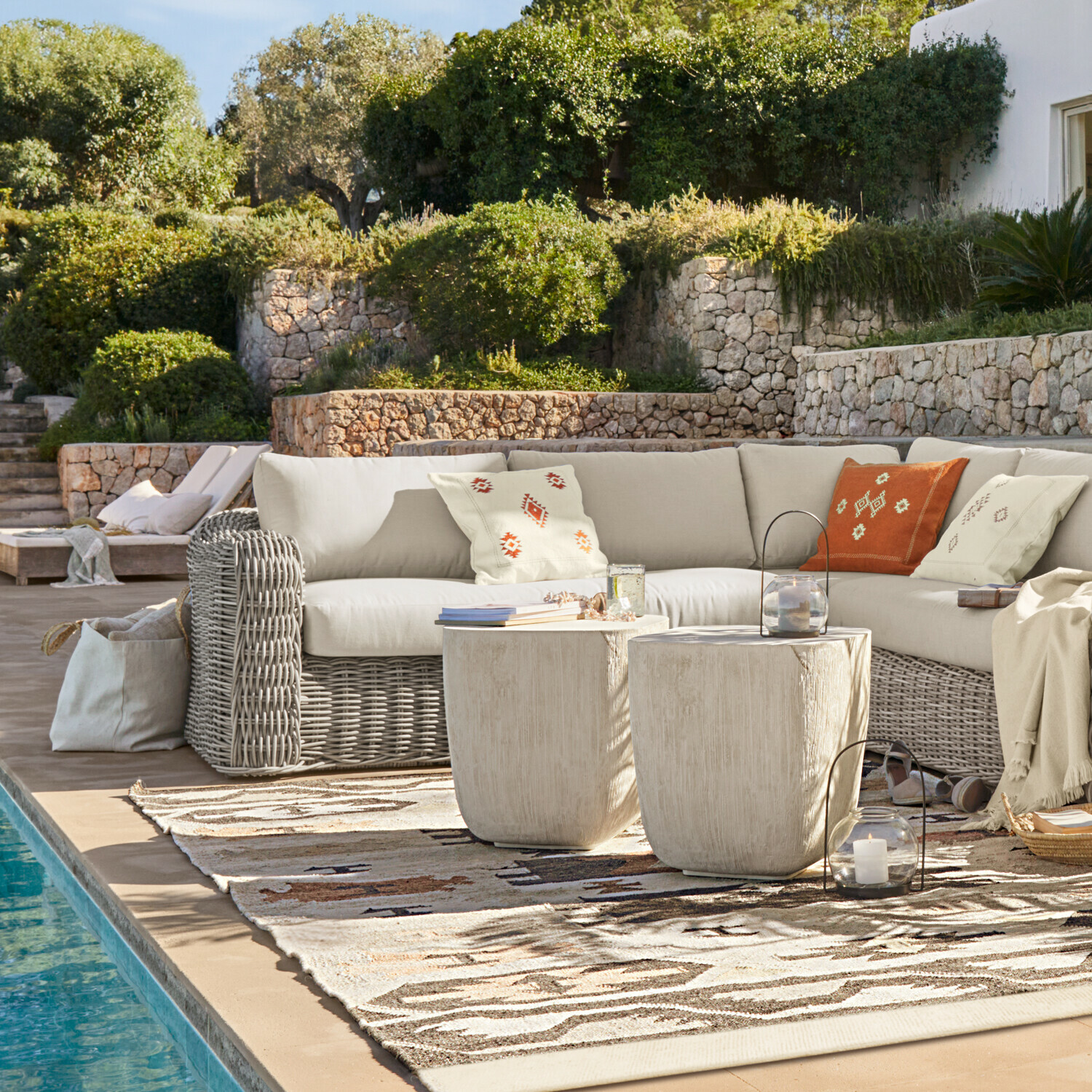 Sofa Eravinto Gartensitzgruppe mit grauem Rattan-Ecksofa und cremefarbenen Kissen neben dem Pool