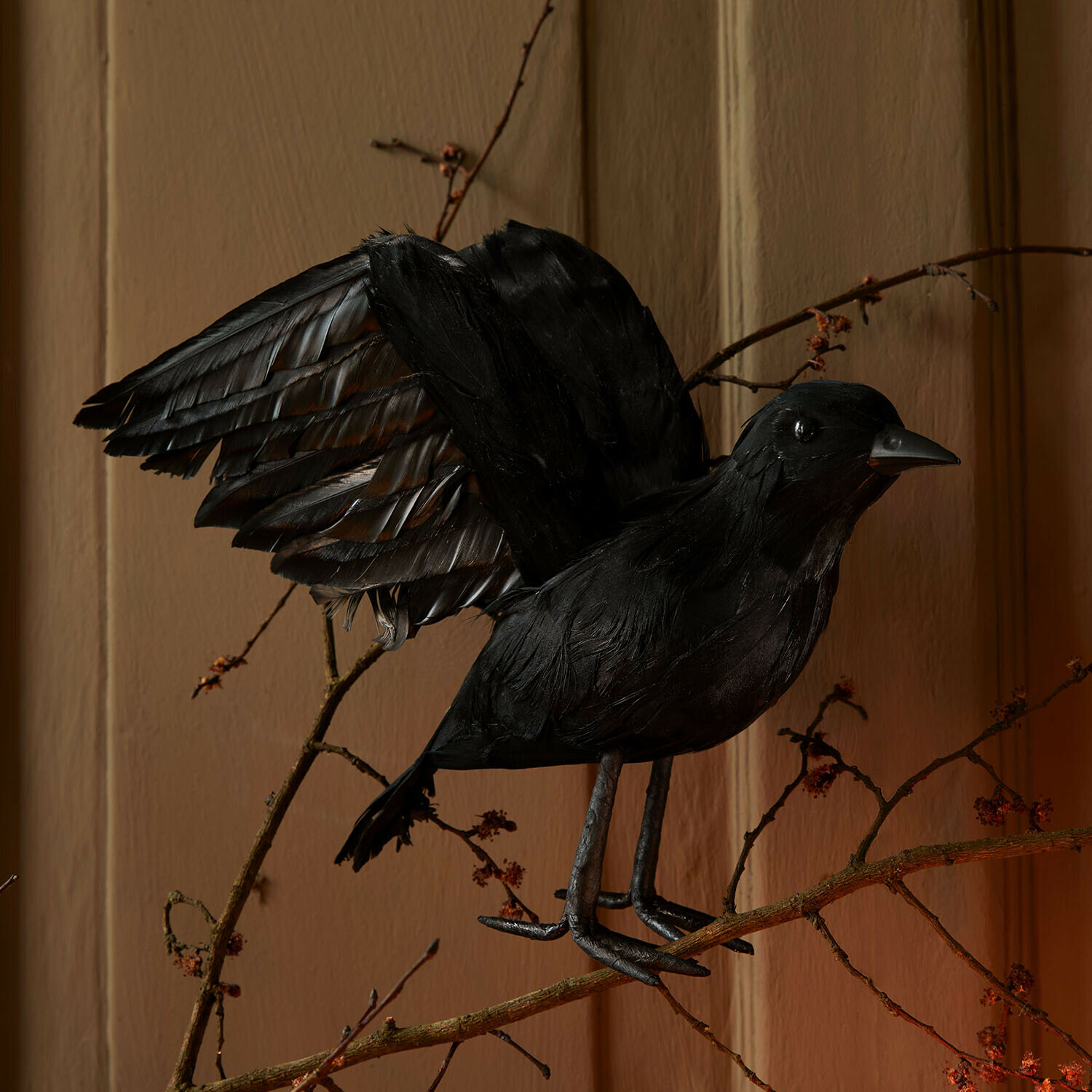 Schwarzer dekorativer Vogel mit ausgebreiteten Flügeln auf Zweig, Innendekoration