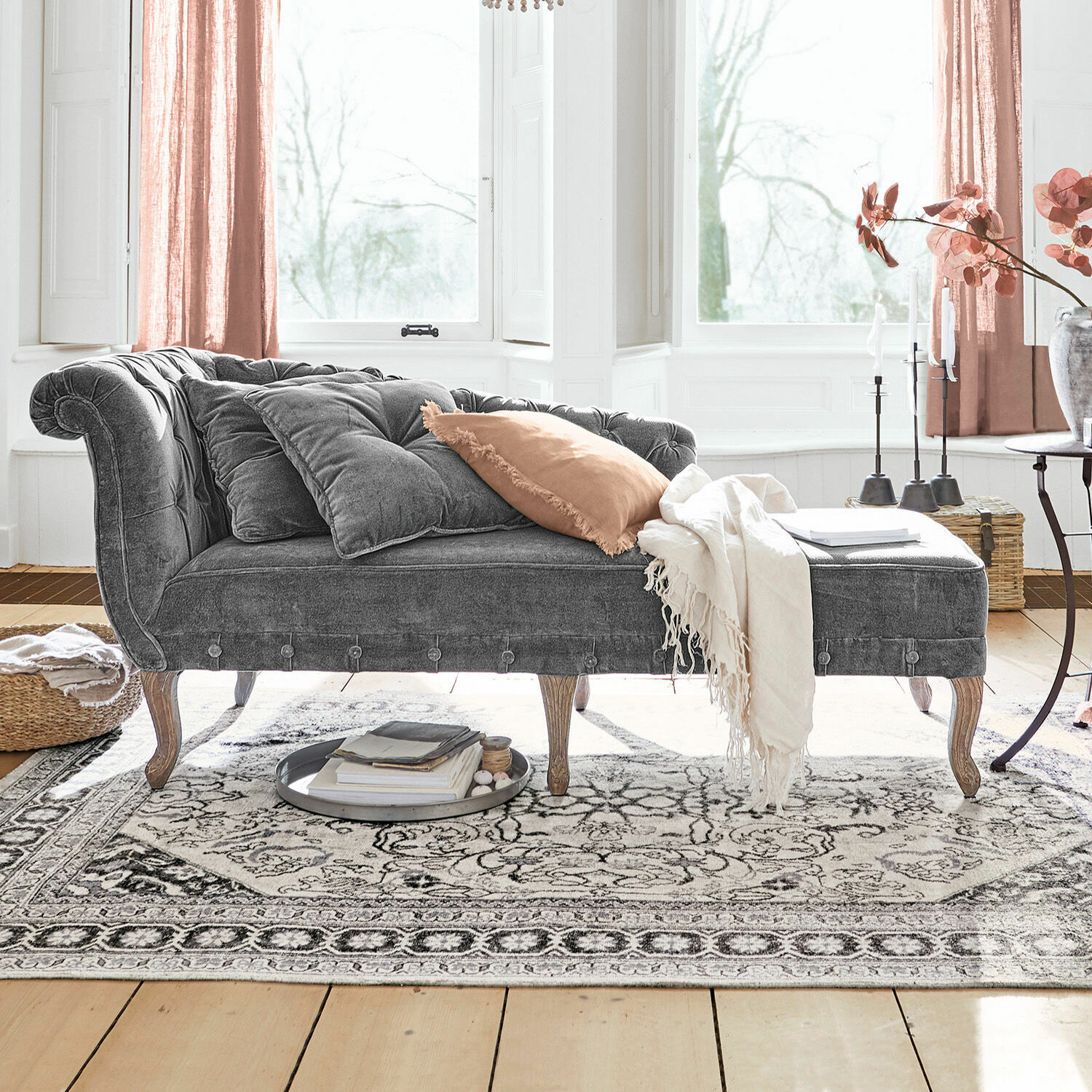 Chaiselongue Viviani Graue Samt-Chaiselongue mit Holzbeinen und hellen Kissen in hellem Wohnzimmer