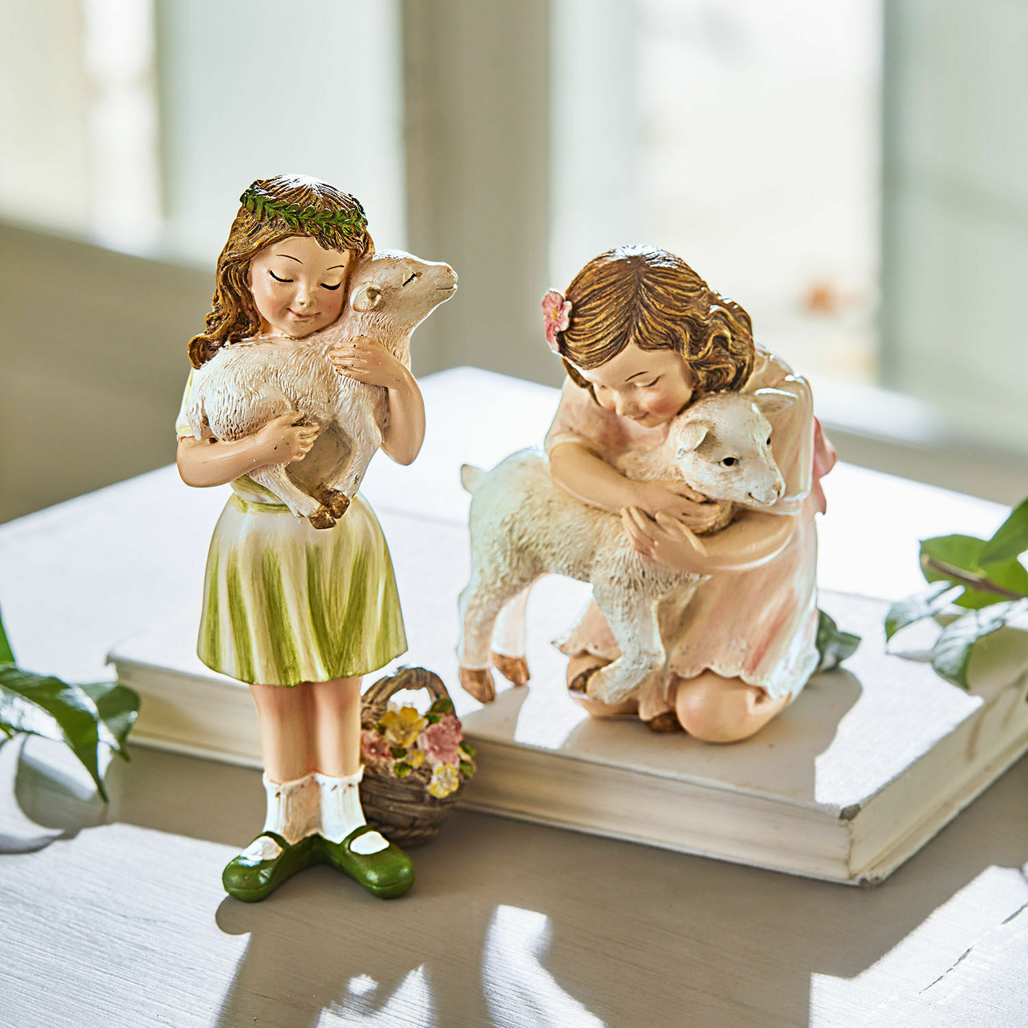 Figur 2er Set Clarisse Figuren von Mädchen mit Lämmern in pastellfarbenen Kleidern auf weißem Tisch, Wohnaccessoire.