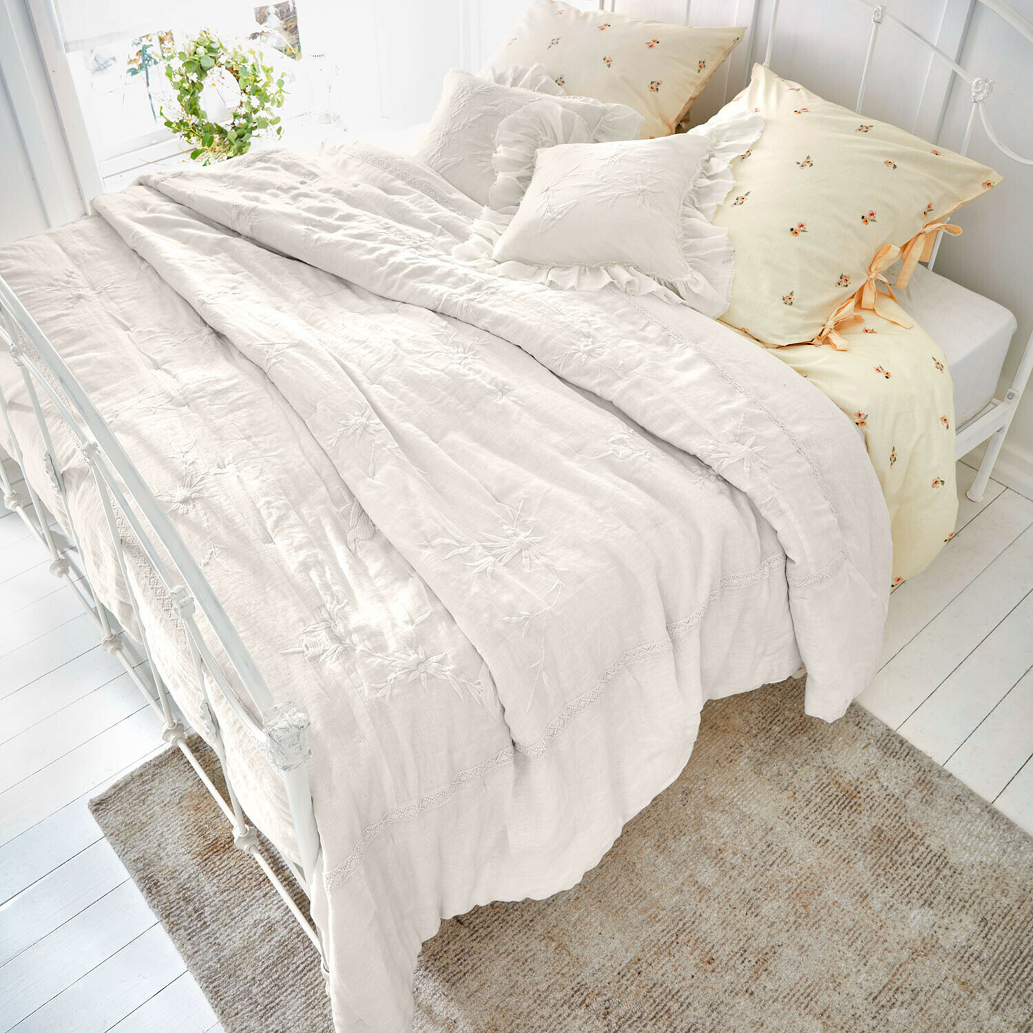 Beige Leinenbettwäsche mit floraler Stickerei und dekorativen Kissen, gemütliche Schlafzimmergestaltung