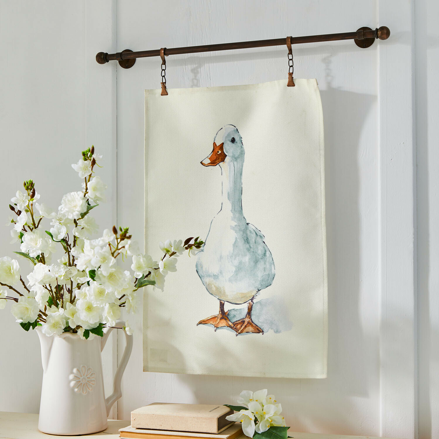 Dekorativer Baumwollstoff mit Entenmotiv in Pastellfarben, an einer Metallstange hängend