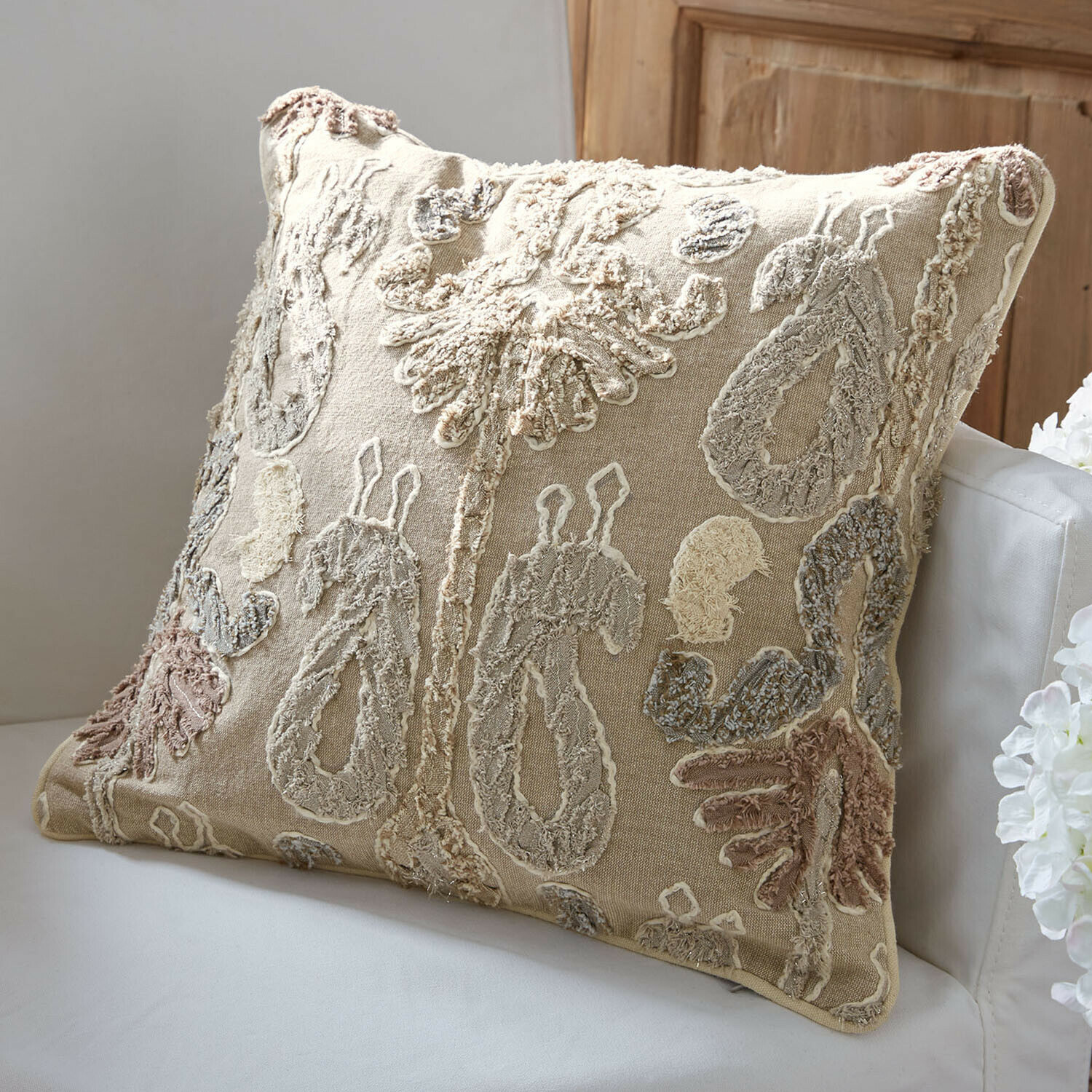 Kissenhülle Rahmira Beige Dekokissen mit besticktem Muster in Naturfarben auf weißem Sofa